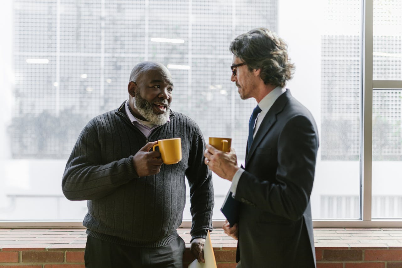 Businessmen Holding Coffee while Having Conversation