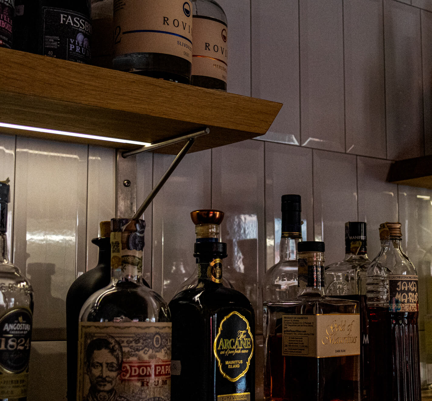Barová police s nabídkou prémiových rumů včetně značek Don Papa a Arcane