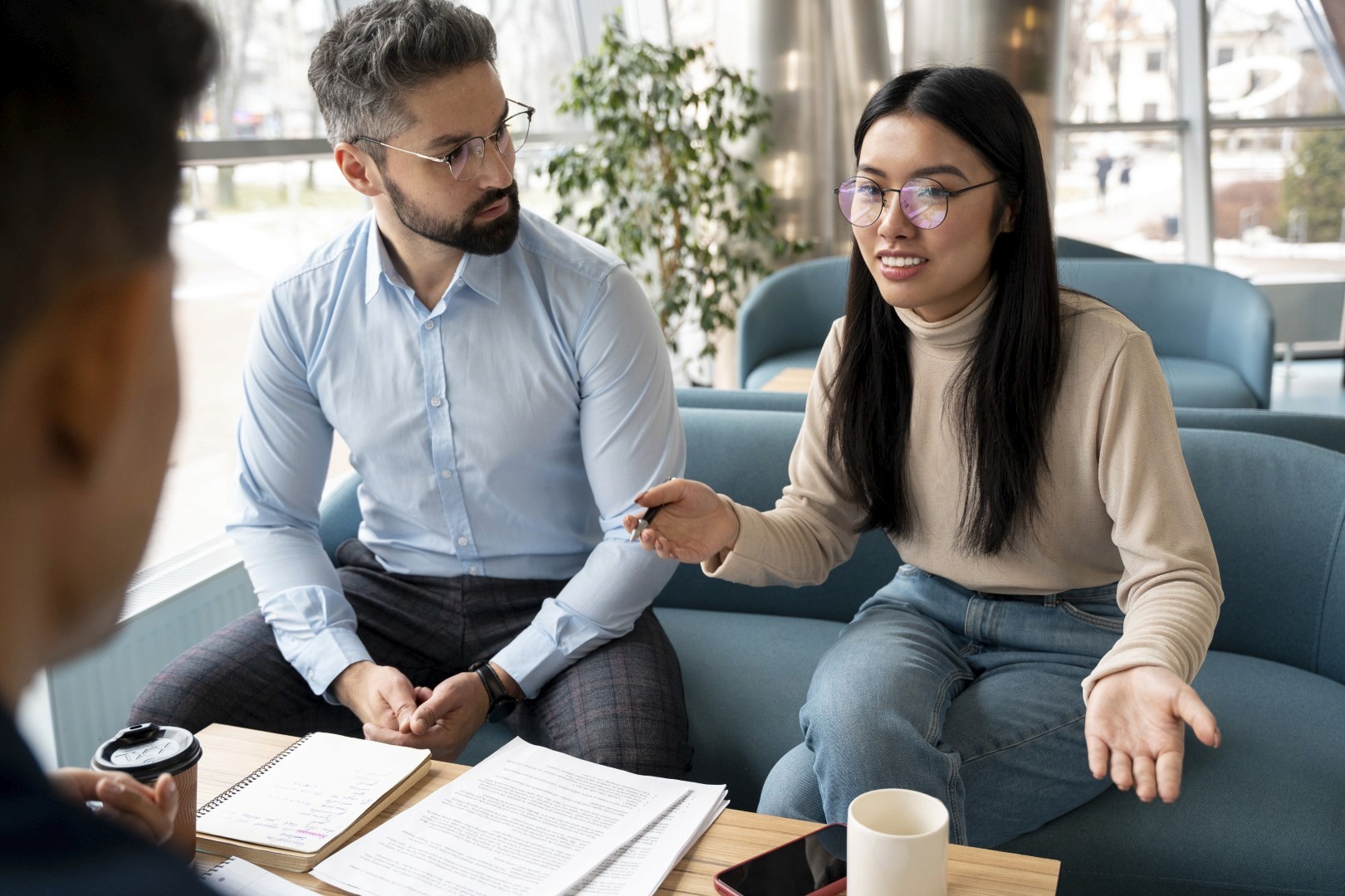 An HR representative and an employee or candidate engaging in a collaborative interview or consultation in a modern office lounge.