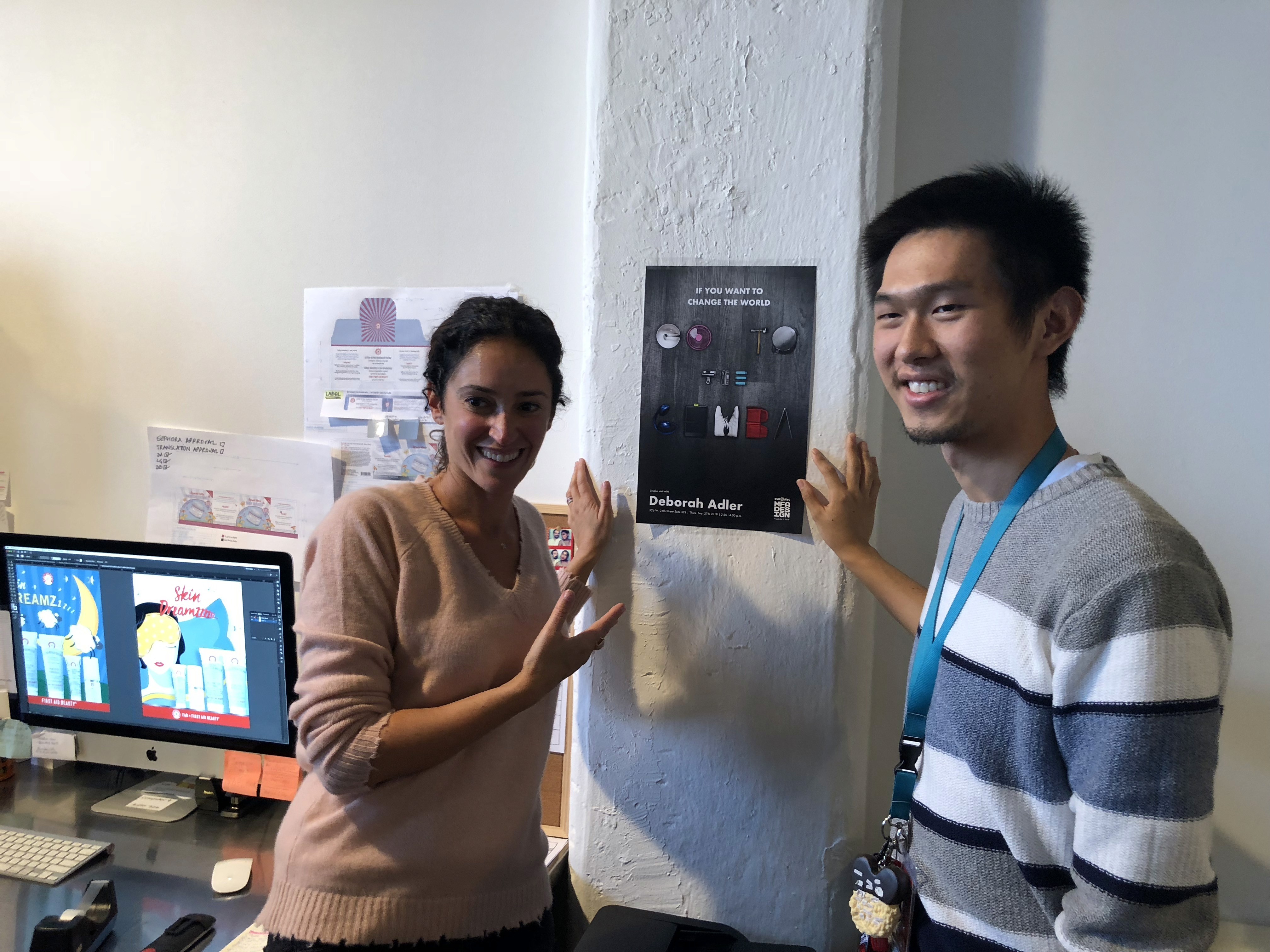 a student and a teacher are installing a poster on the wall