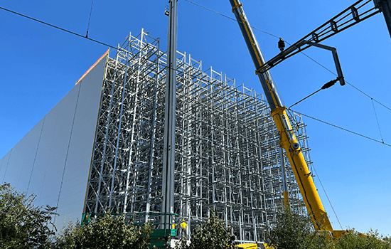 Four diverse professionals collaboratively working on a laptop, with one person pointing at the screen while others observe.