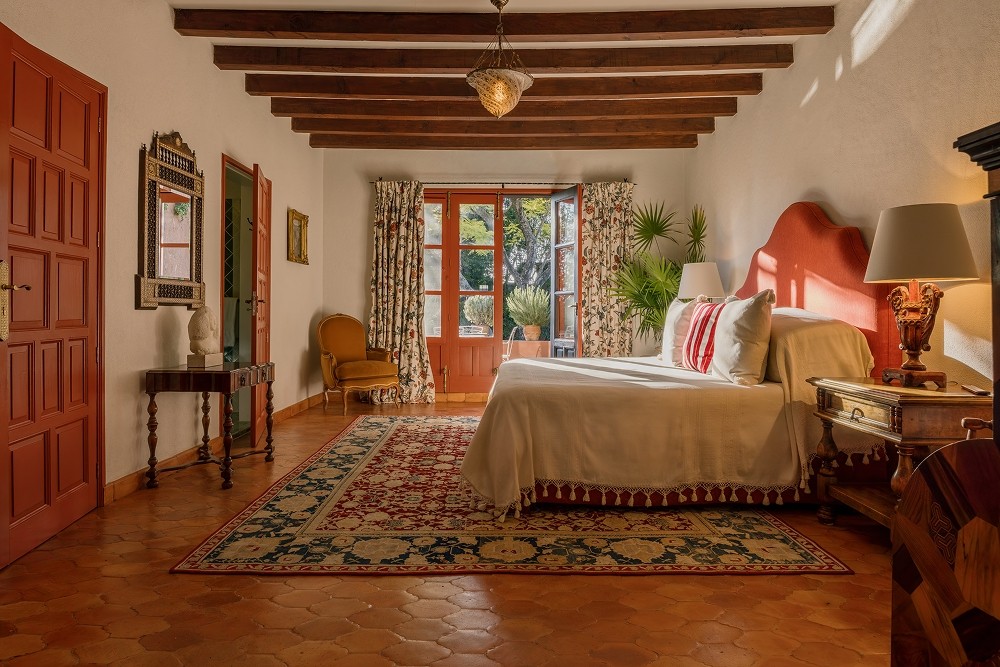 La Residencia San Miguel covered veranda with arched columns, mosaic tile table, and garden view