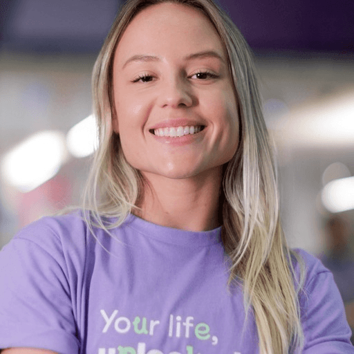 Uma pessoa sorridente, vestindo um suéter verde claro. Atendimento da BuilderSession