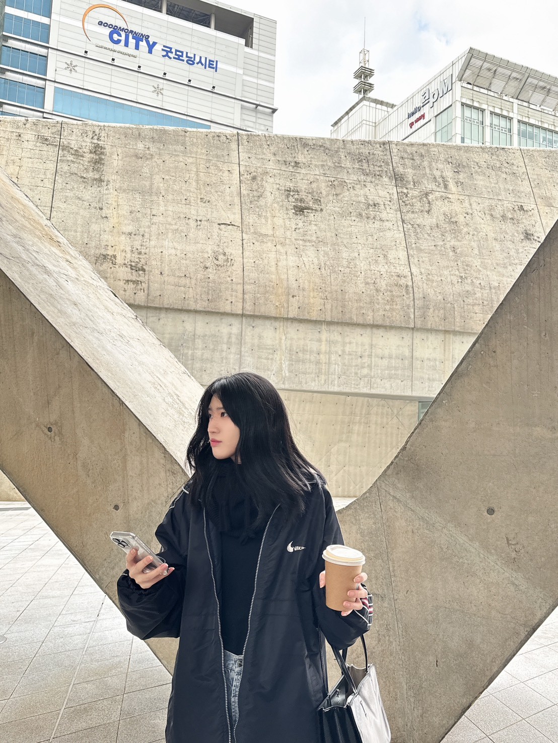 Close-up portrait of a freckled woman with soft pink hair and star earring, natural light, white tank top.