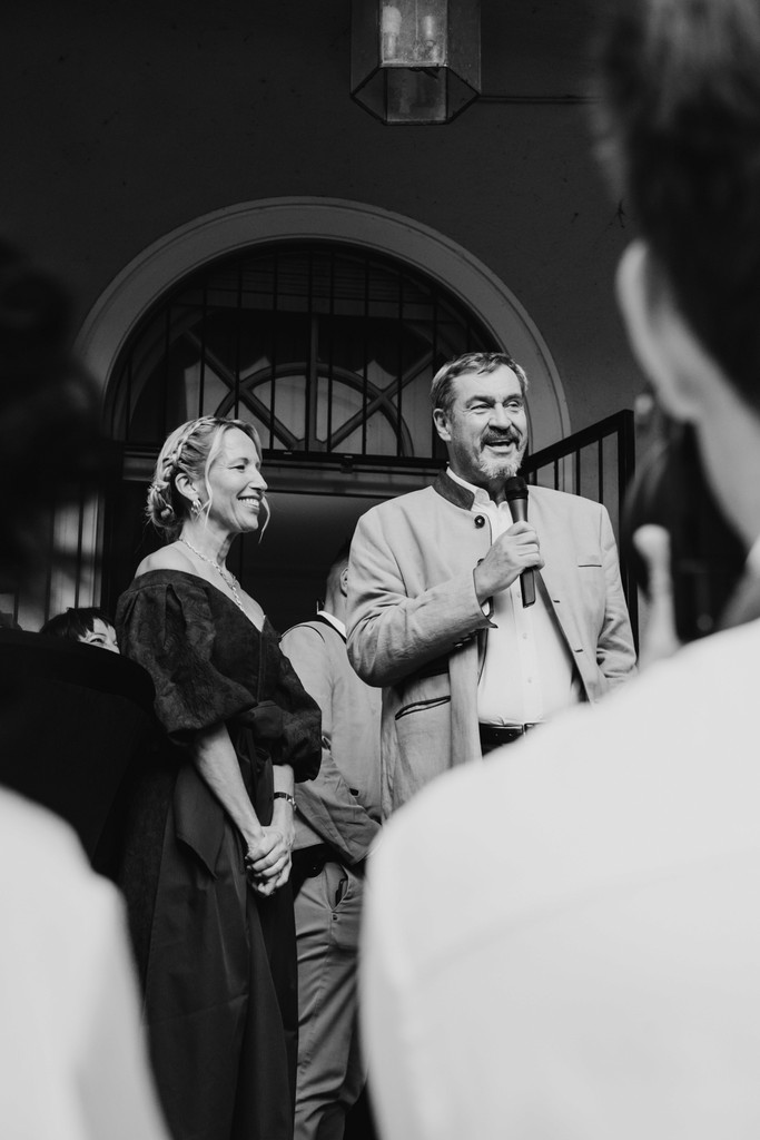 Two speakers presenting outdoors in a professional setting