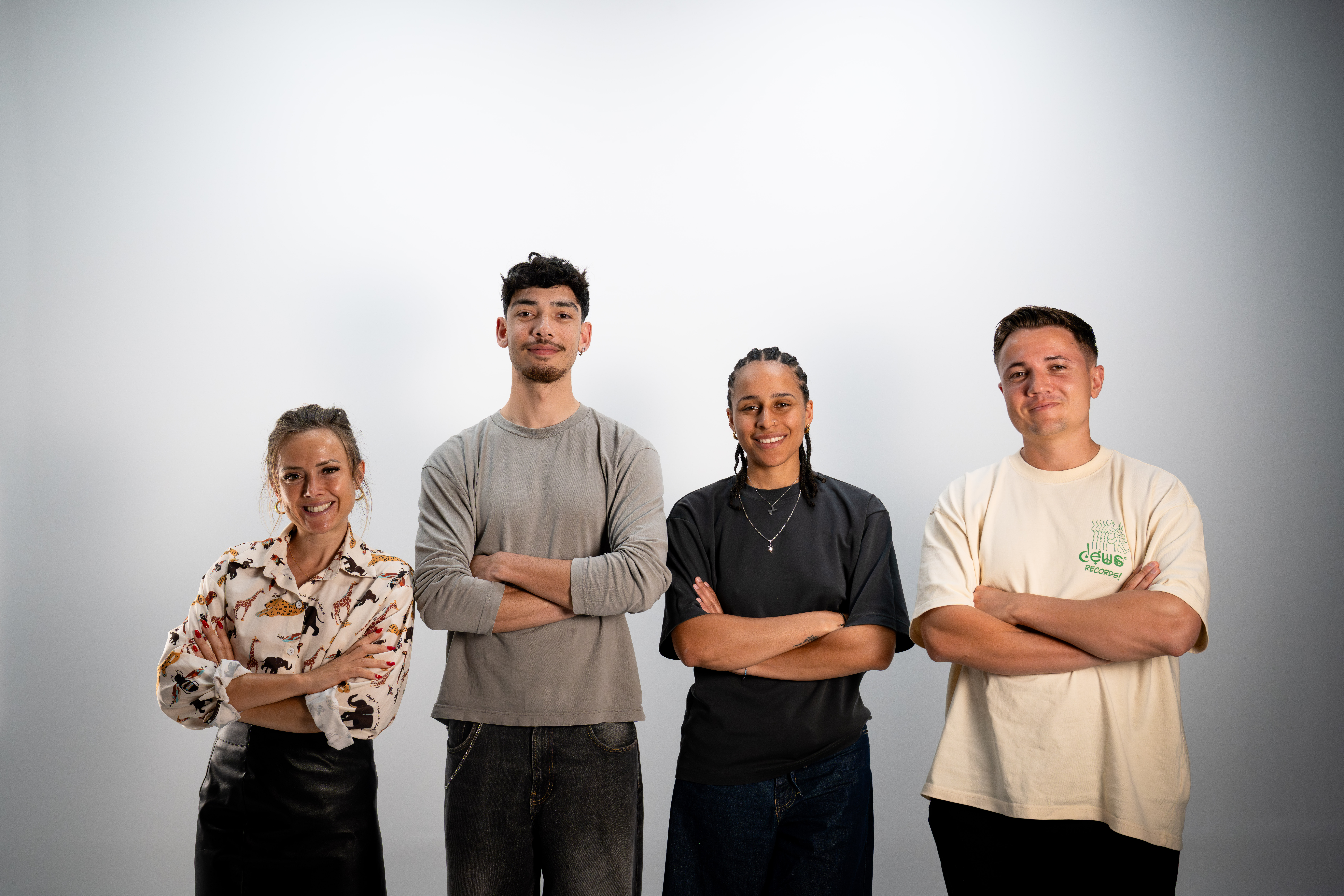 Four diverse professionals collaboratively working on a laptop, with one person pointing at the screen while others observe.