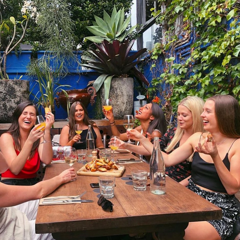 Une main remplie un verre de rosé pendant un brunch