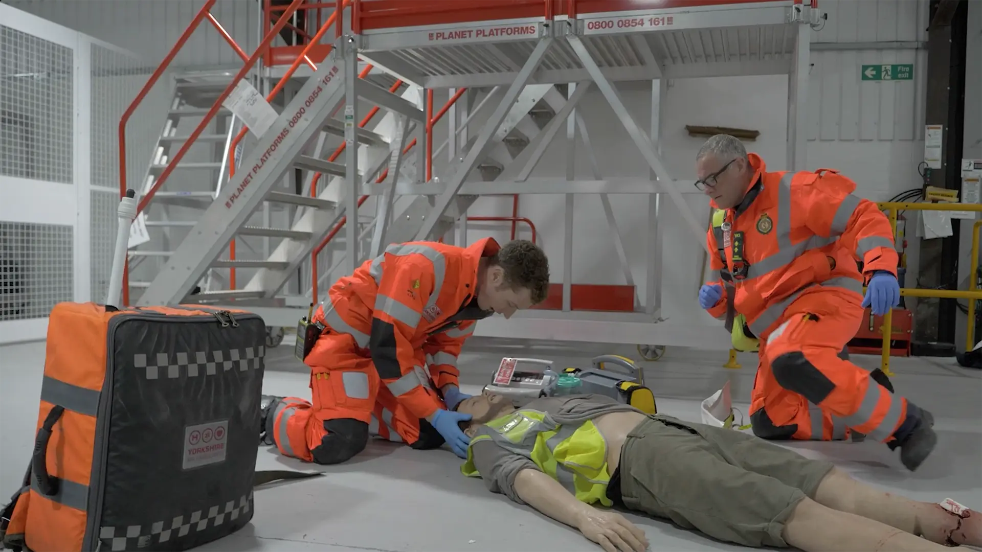Yorkshire Air Ambulance crew taking part in a medical training scenario inside a hangar.