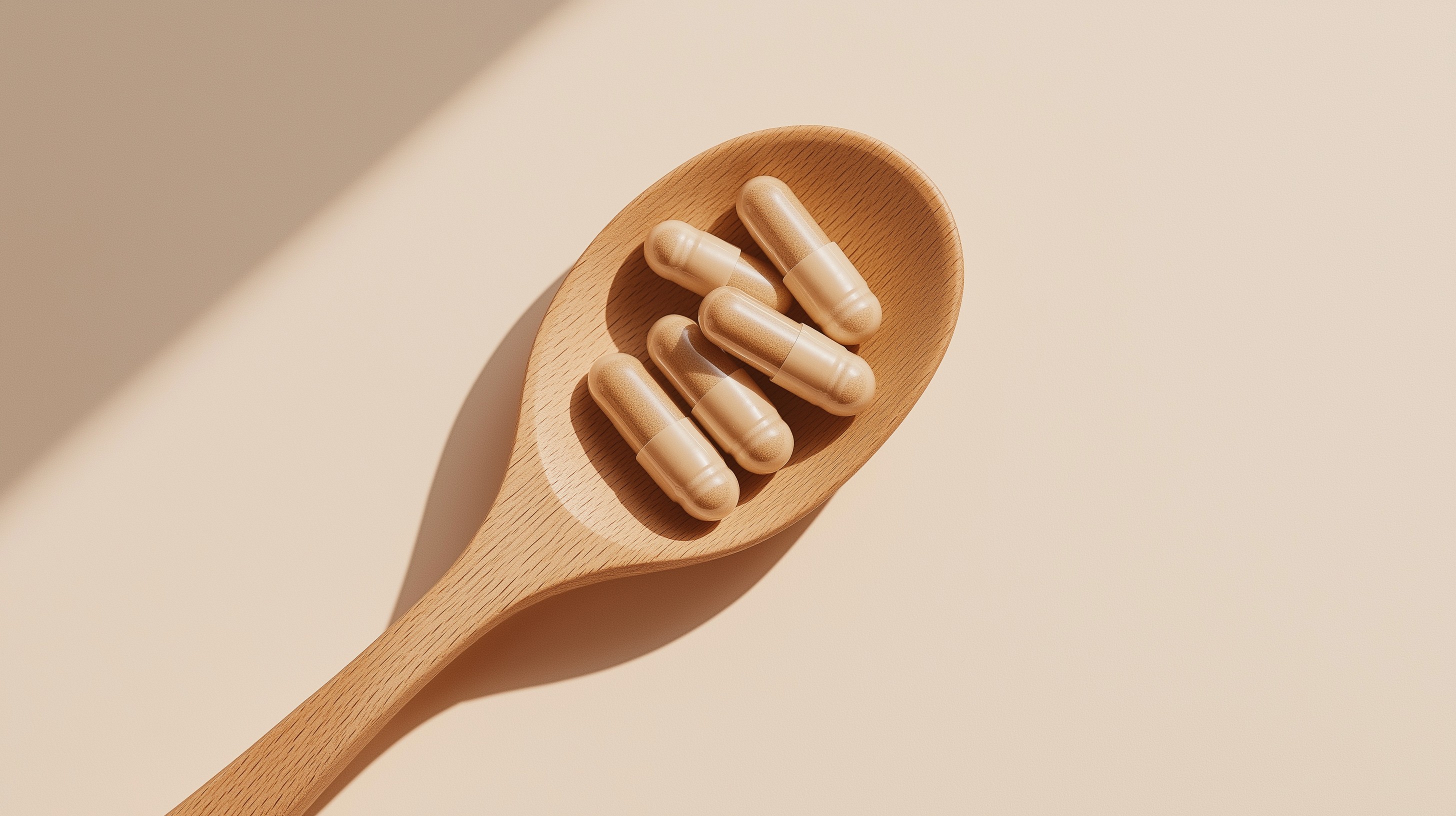 Skin Supplement capsules on a wooden spoon