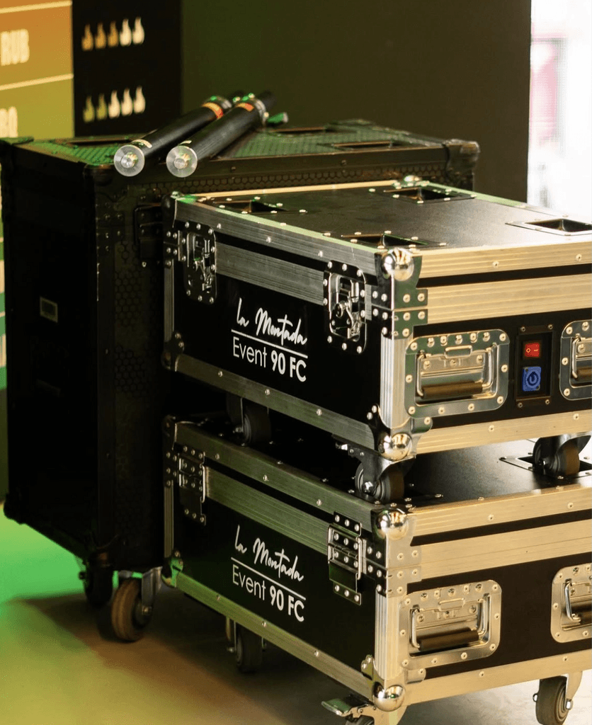 A smiling man with short hair stands with arms crossed, wearing a dark shirt against a neutral background.