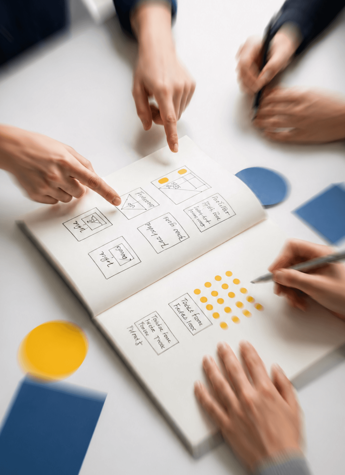 Close-up of a team brainstorming and planning a digital campaign layout in an open notebook.