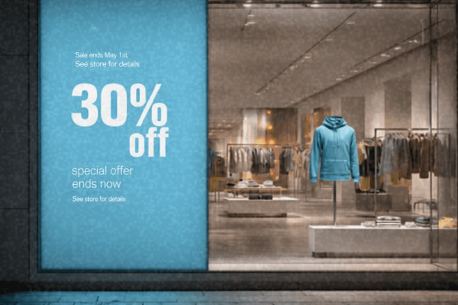 Two men discuss a project while standing at a laptop in an office.