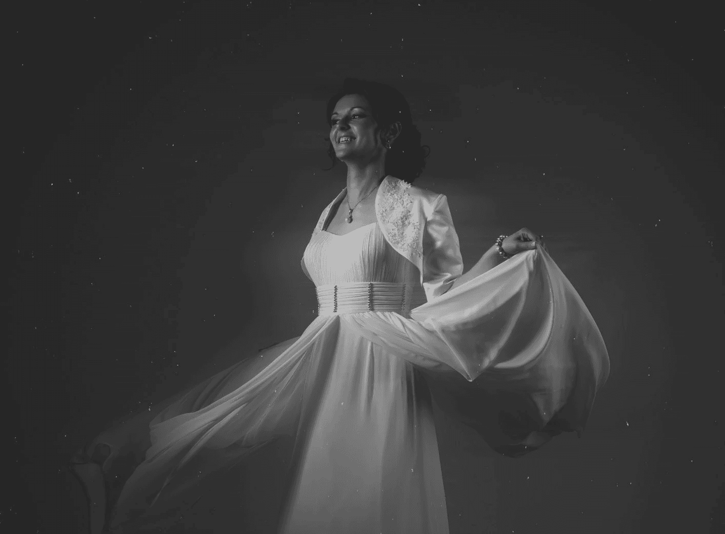 Black and white image of people working at a table with laptops, showing hands gesturing during discussion of digital content displayed on screens, with fabrica® logo in the corner.