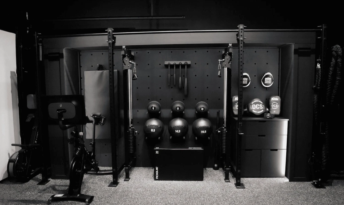 Luxury home gym with mirrored walls, dumbbell and kettlebell storage, designed for functional training.