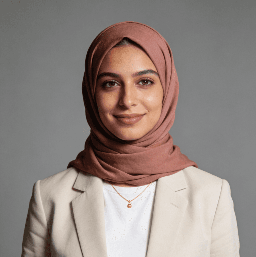 A woman wearing a hijab paired with a white blazer, exuding elegance and professionalism in her attire.
