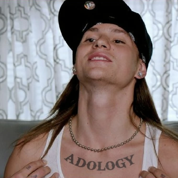 Meme of a person proudly showing an ADOLOGY chest tattoo