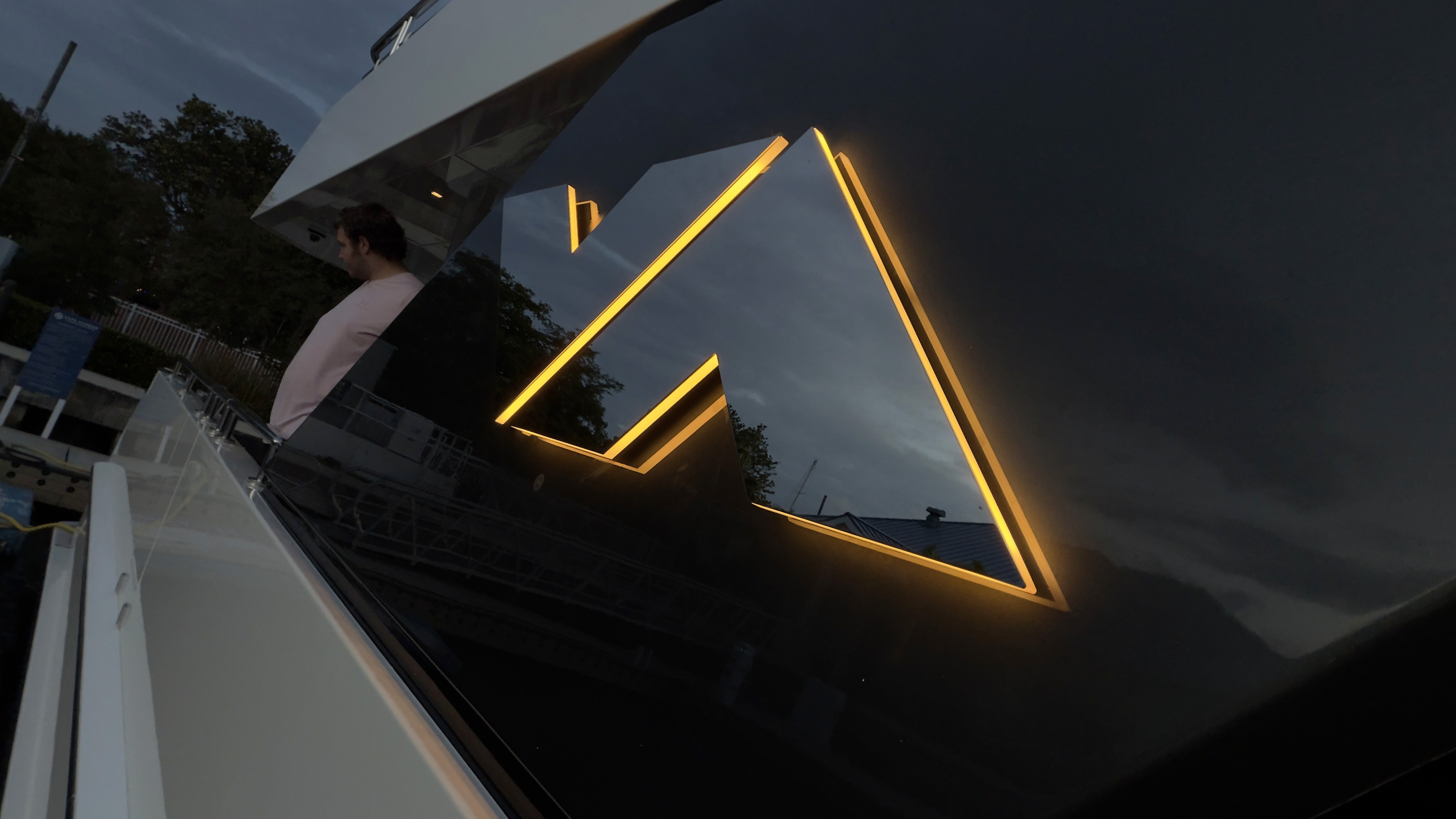 Gold LED illuminated custom yacht logo on dark hull