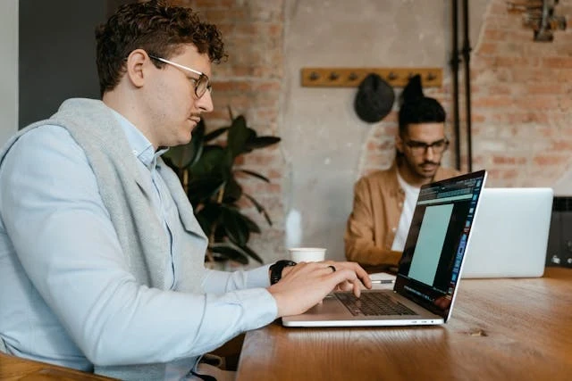 Homem trabalhando no notebook em ambiente corporativo, representando como funciona suporte estratégico da franqueadora para gestão e expansão de redes.