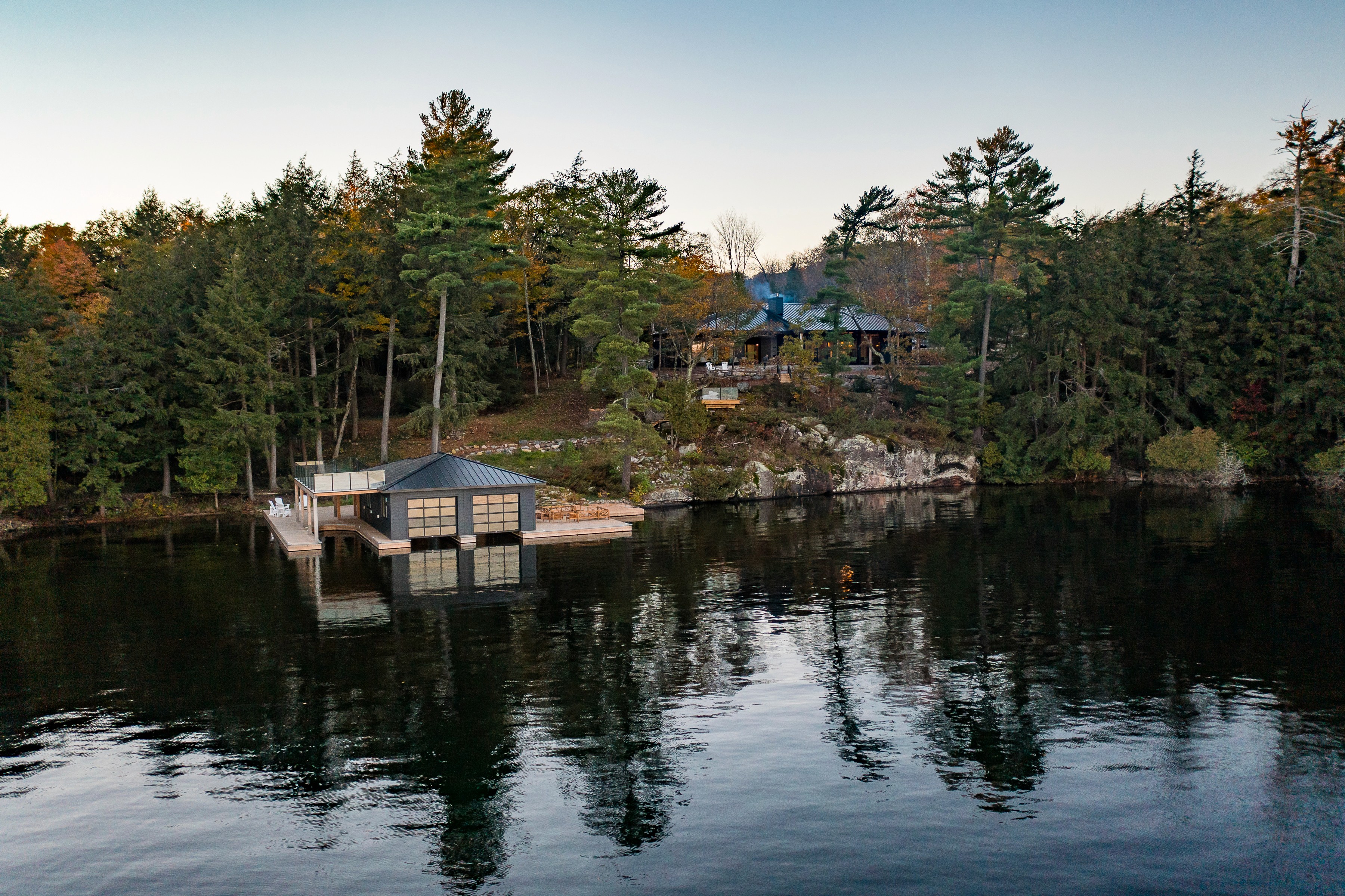 Modern Scandinavian-inspired custom home with black vertical cladding, steep roof forms, and thoughtfully integrated landscape design