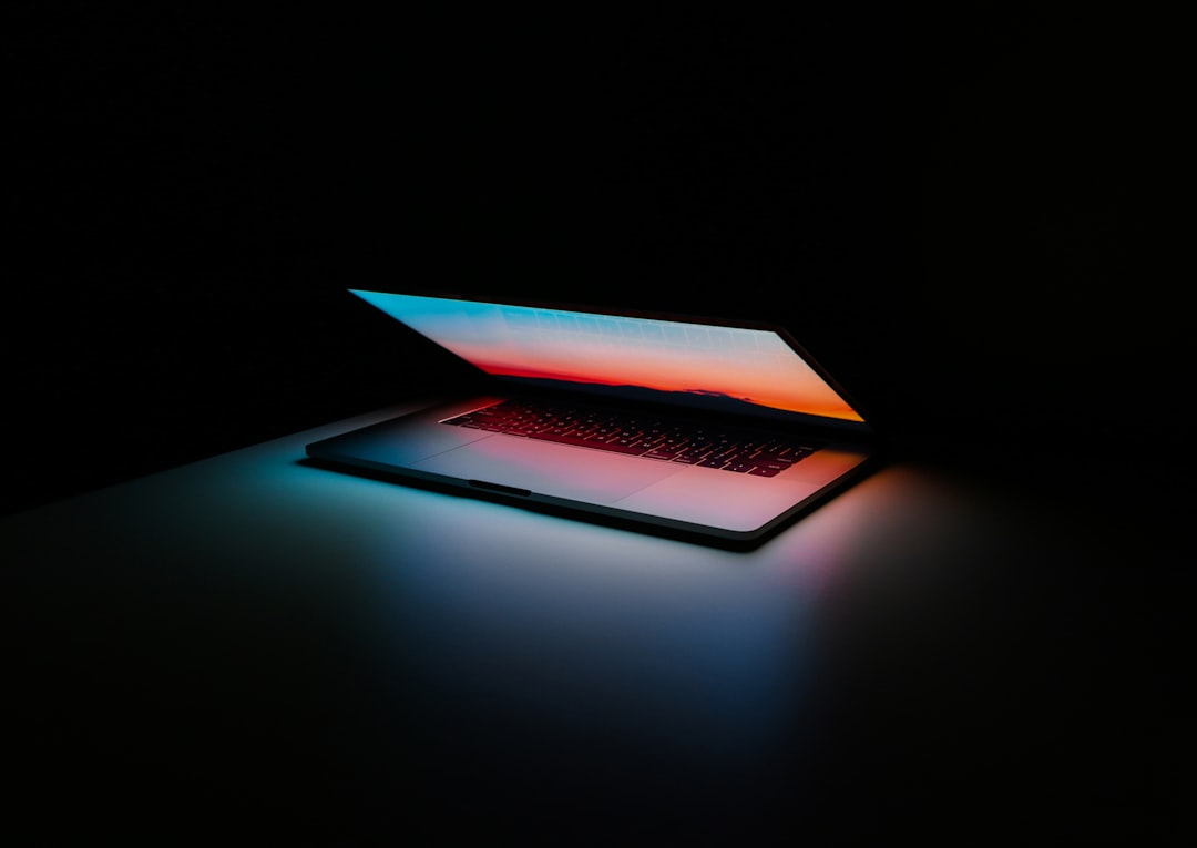 close-up of a laptop screen displaying a complex dashboard of clinical data fields, a stethoscope draped over the side, professional office lighting