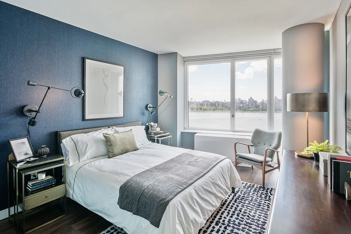 A cozy bedroom featuring blue walls and a neatly made bed, creating a serene atmosphere.