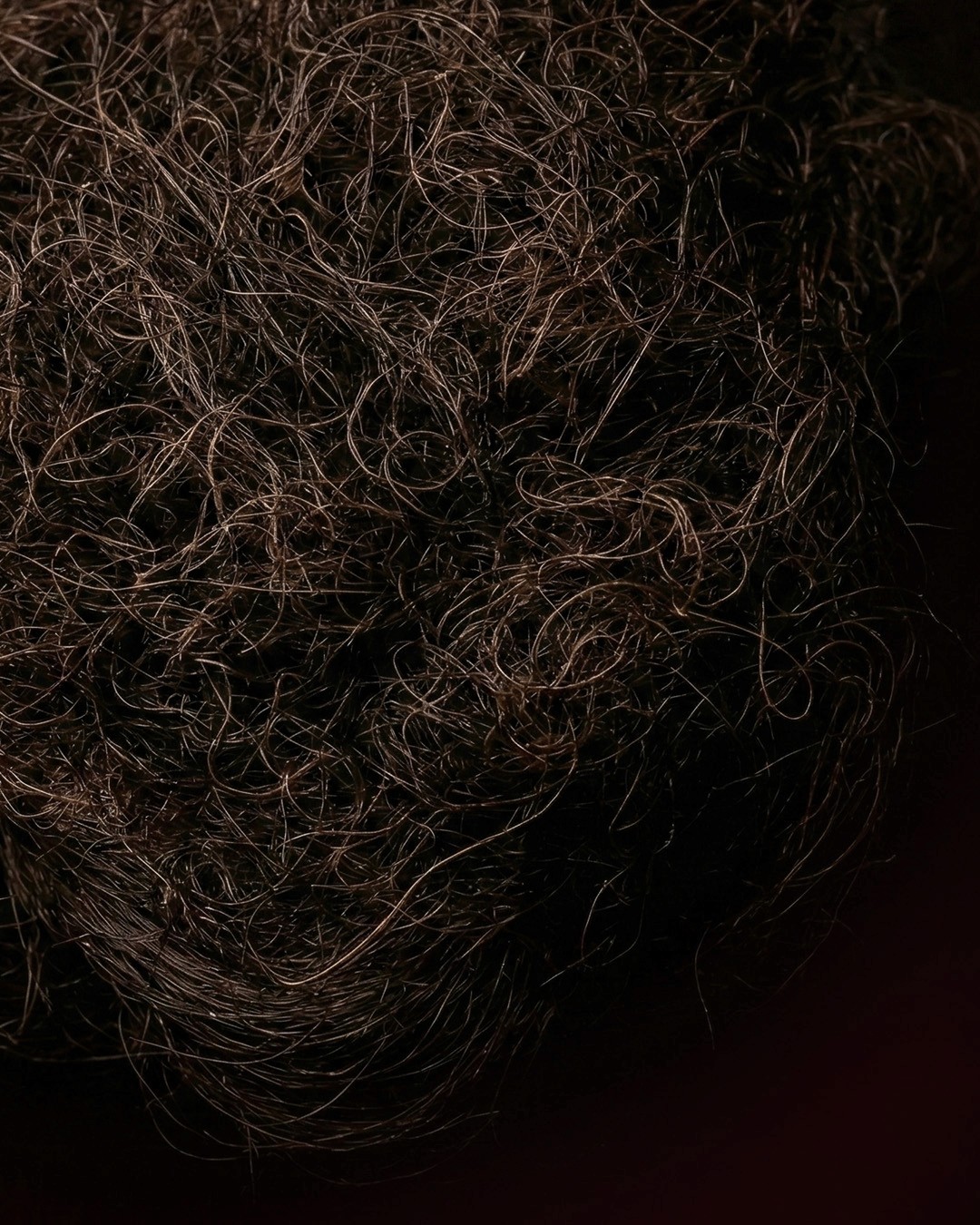 Beige interior with natural stone walls, sunlight, and geometric shadows over a calm water pool.