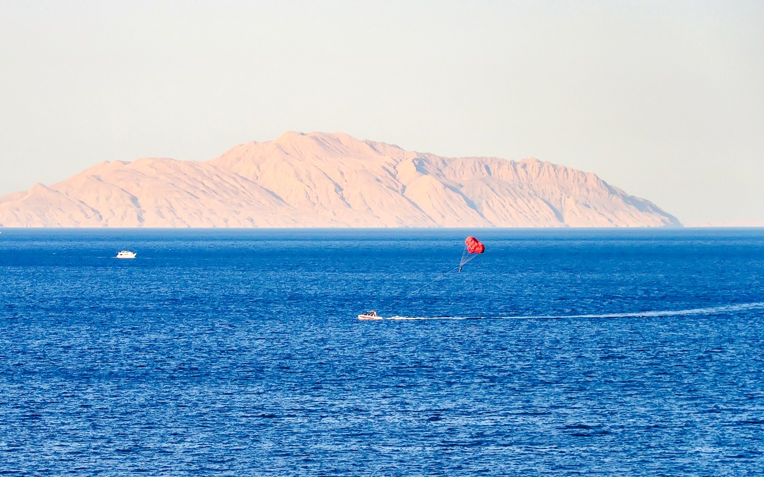 Parasailing over the Red Sea with Ras Mohammed National Park mountains in the background.