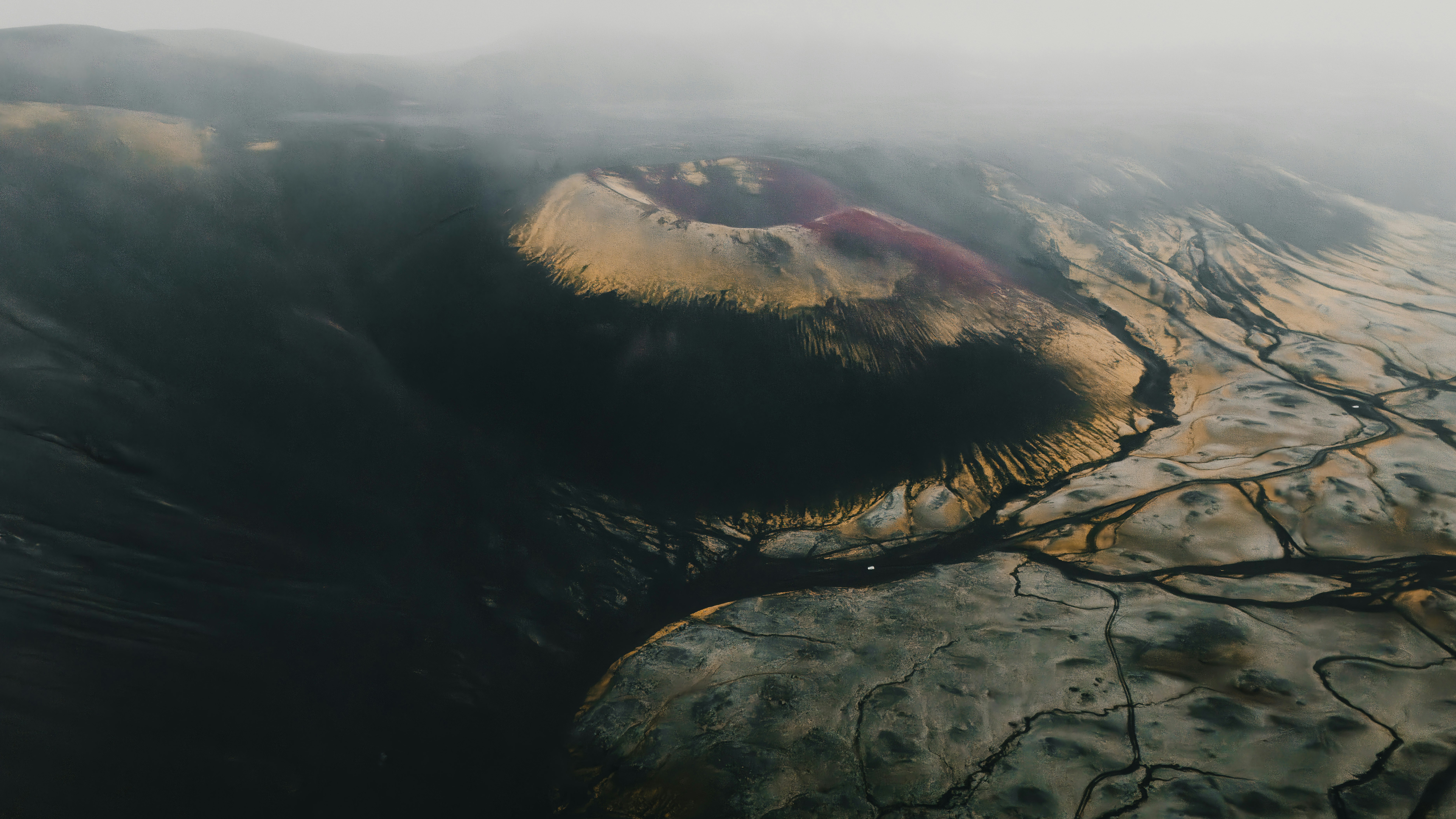 Aerial view of a volcanic crater with colorful mineral deposits