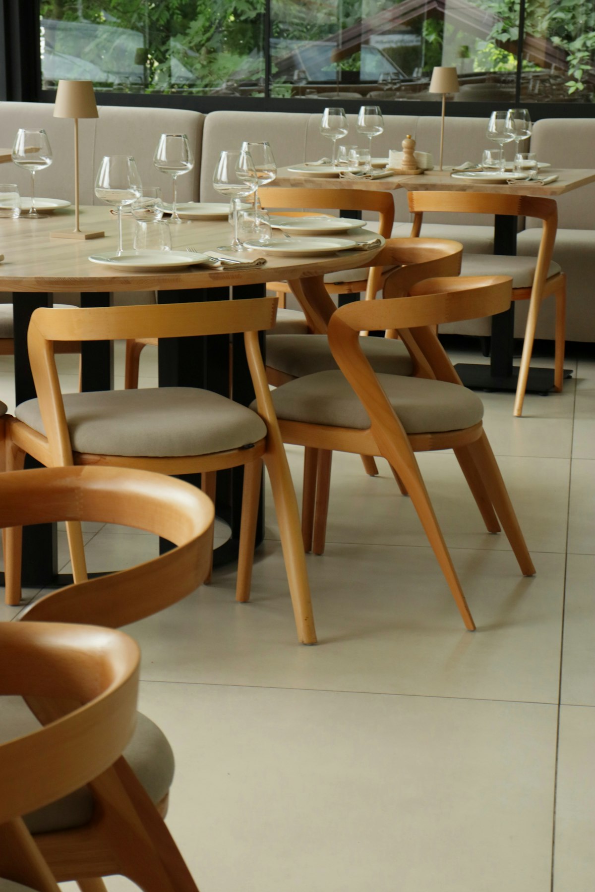 Mesas montadas con copas y vajilla en un comedor vacío antes del servicio