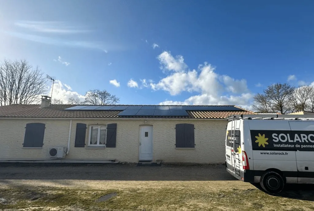 Photo du toit d'une maison en Nouvelle-Acquitaine équipée de panneaux solaires dont l'installation a été faite par Solarock. On voit aussi un camion Solarock à droite de la photo