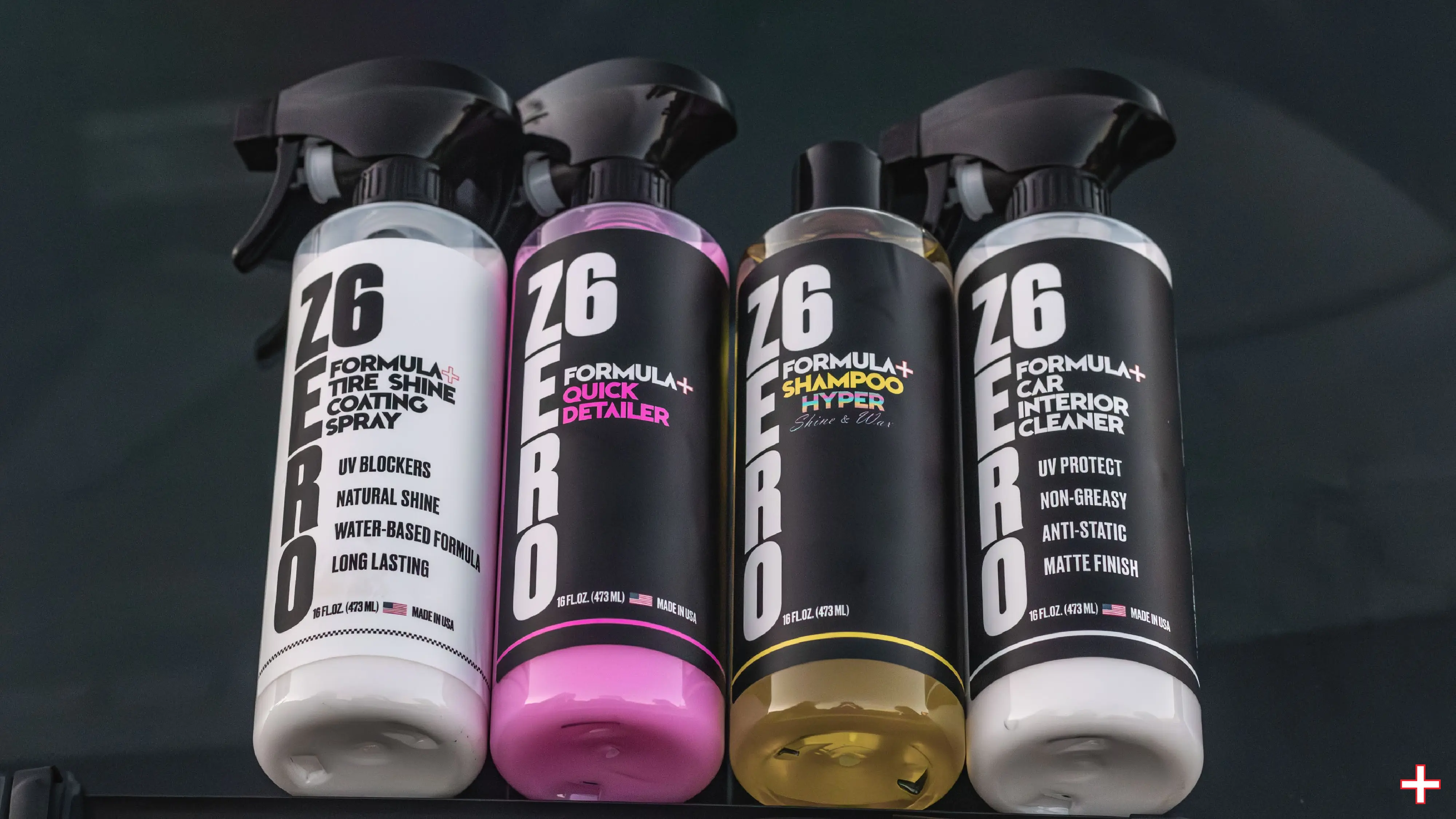 Four bottles of Z6 Zero Formula+ car care products, including Tire Shine Coating Spray, Quick Detailer, Shampoo Hyper, and Car Interior Cleaner, are displayed on a dark surface, showcasing their sleek black, pink, and yellow packaging designs.