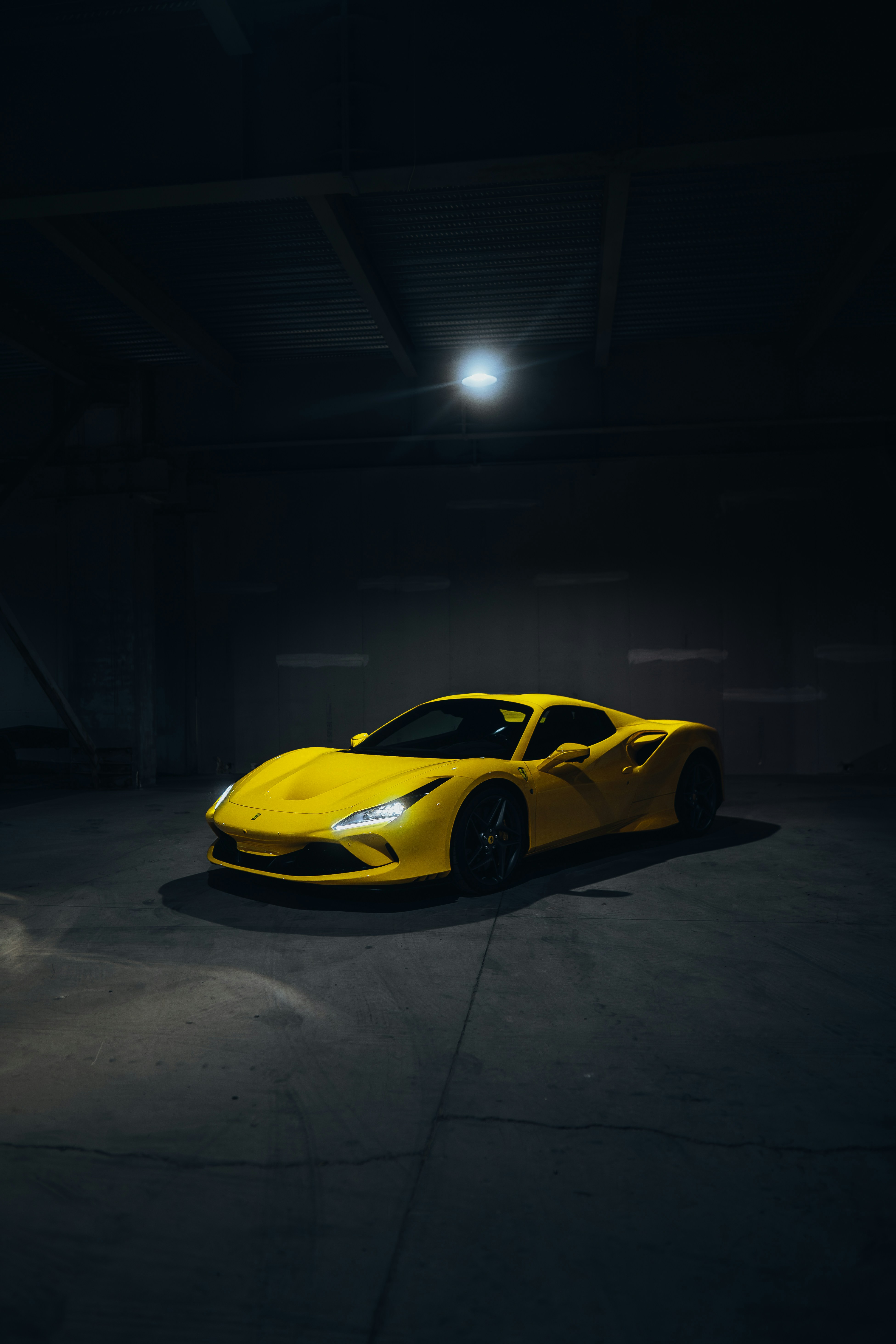 a yellow sports car parked in a dark garage