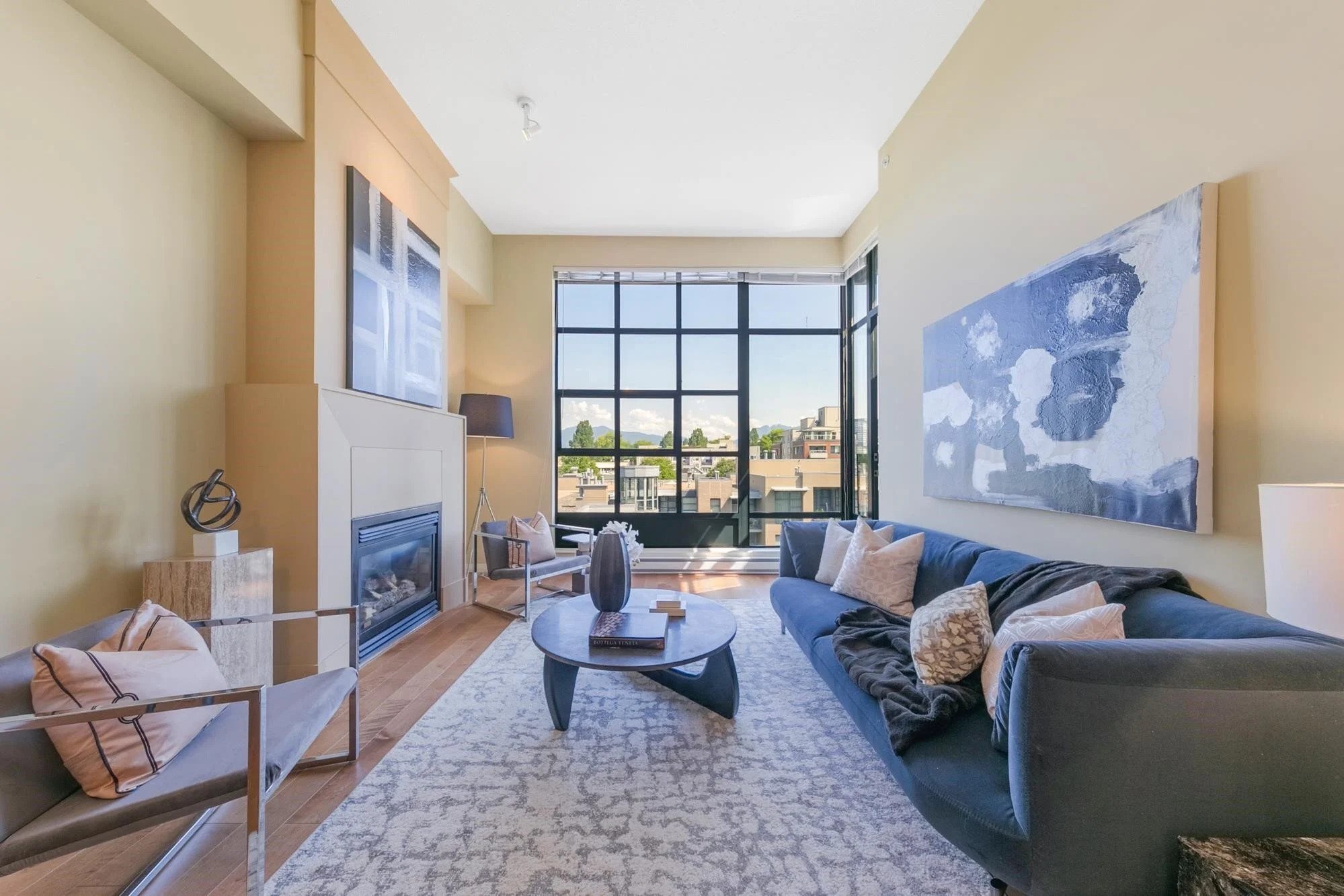 A modern living room featuring large windows, a comfortable seating area, and contemporary decor.