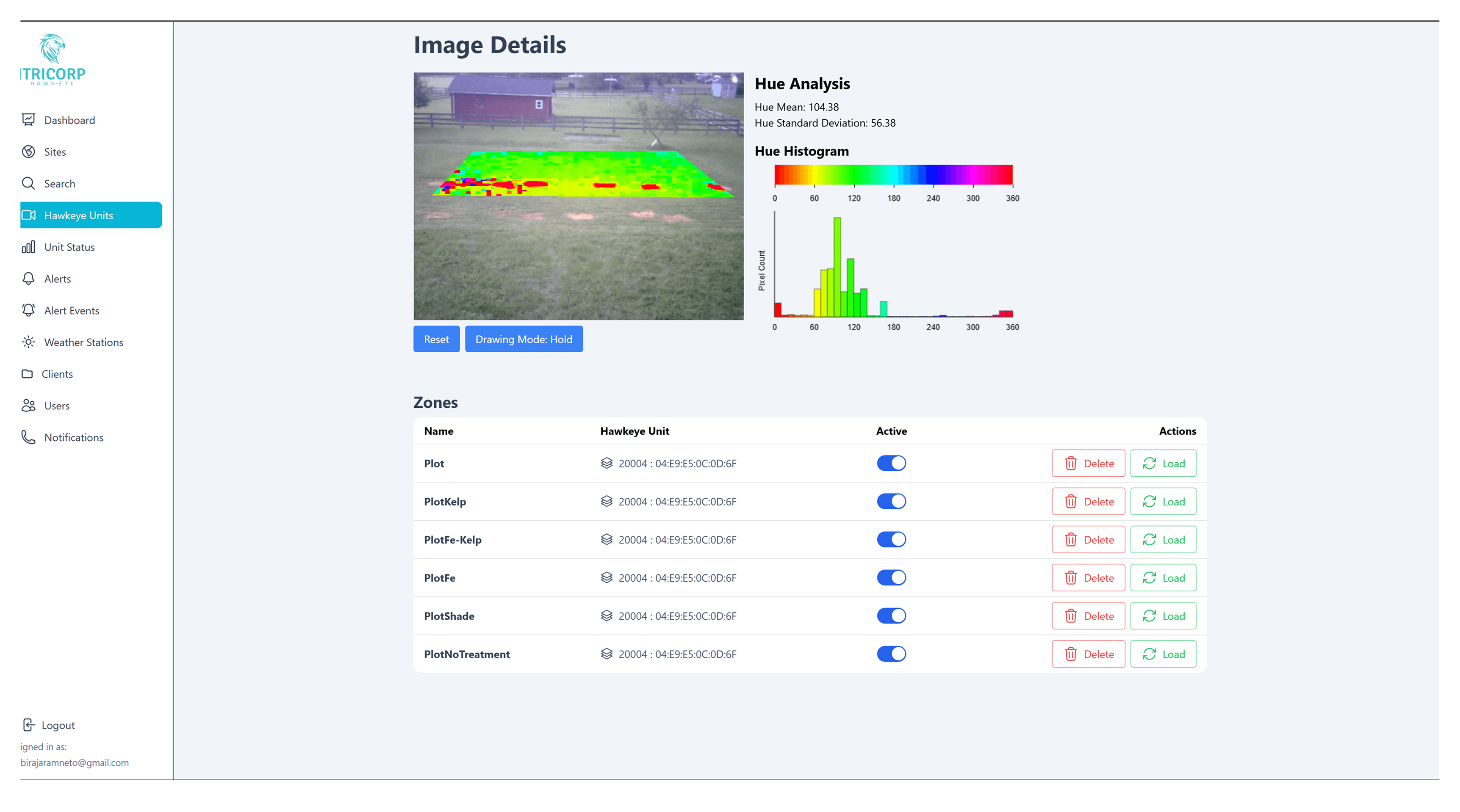 A large orange truck driving down a dirt road