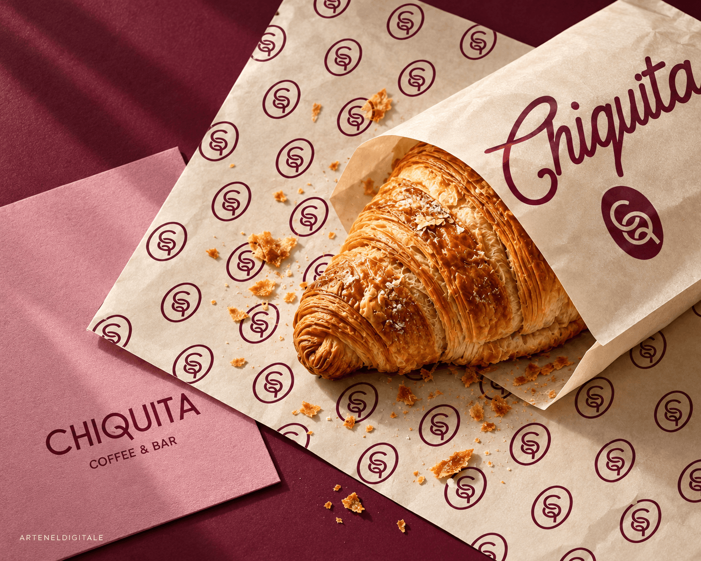 غلاف الكرواسان لـ Chiquita Coffee & Bar مع حافظة ورقية بلون كريمي، ونقش مونوغرام باللون البرغندي، مع ورق فاخر يحمل الهوية التجارية باللون الوردي المغبر.