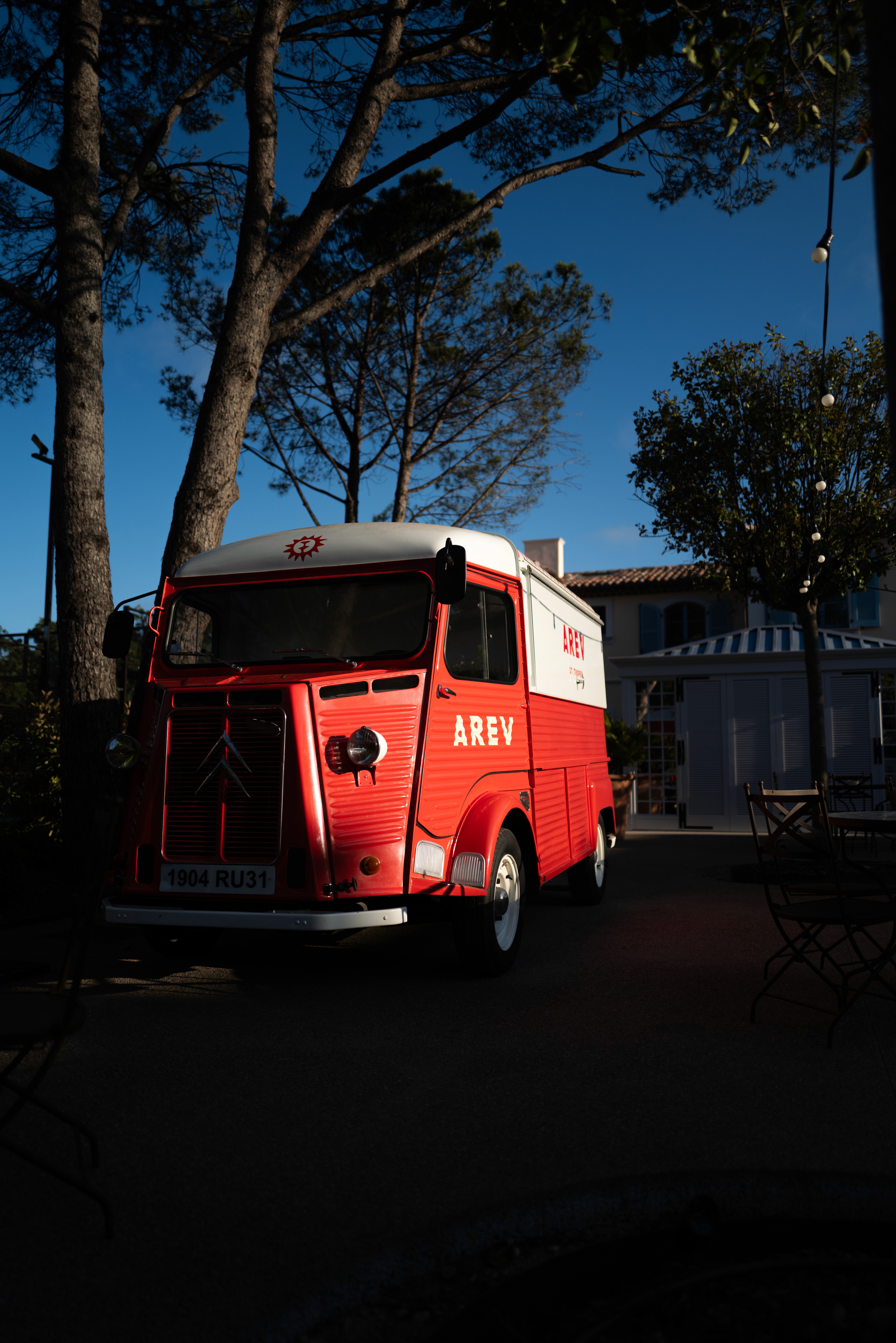 Bride sitting on ground against wall, groom standing nearby