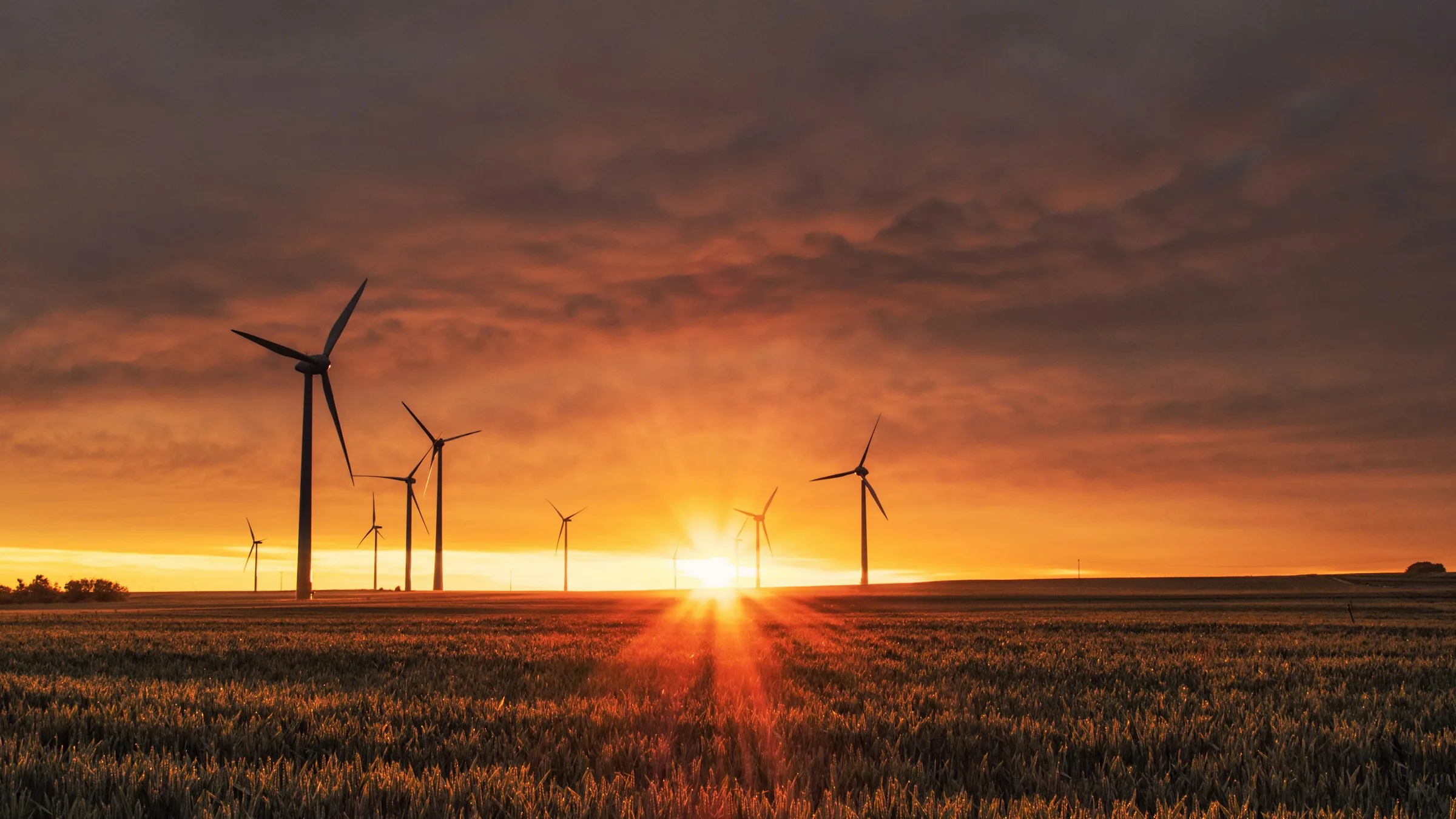 Wind turbine on a grassy hill at golden hour, the kind of project financed with a long-term offtake agreement