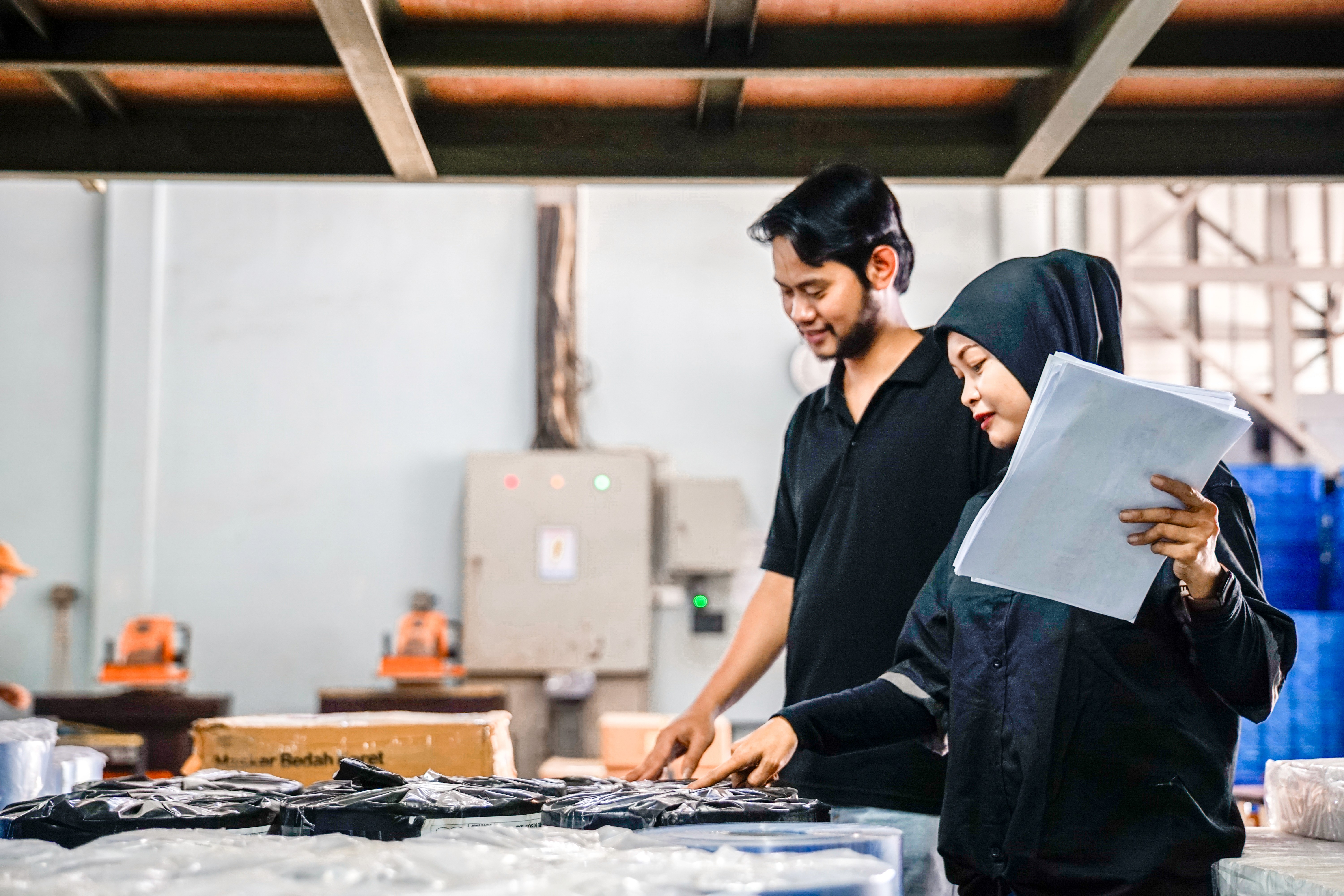 Dua orang pekerja sedang melakukan quality control pada kemasan plastik yang telah selesai diproduksi di area produksi pabrik kemasan. Pemeriksaan akhir kualitas kemasan plastik oleh dua karyawan di pabrik manufaktur, Proses QC kemasan blister plastik oleh tim quality control di industri pengemasan, Dua staf produksi sedang memeriksa kualitas hasil cetakan kemasan plastik siap kirim.