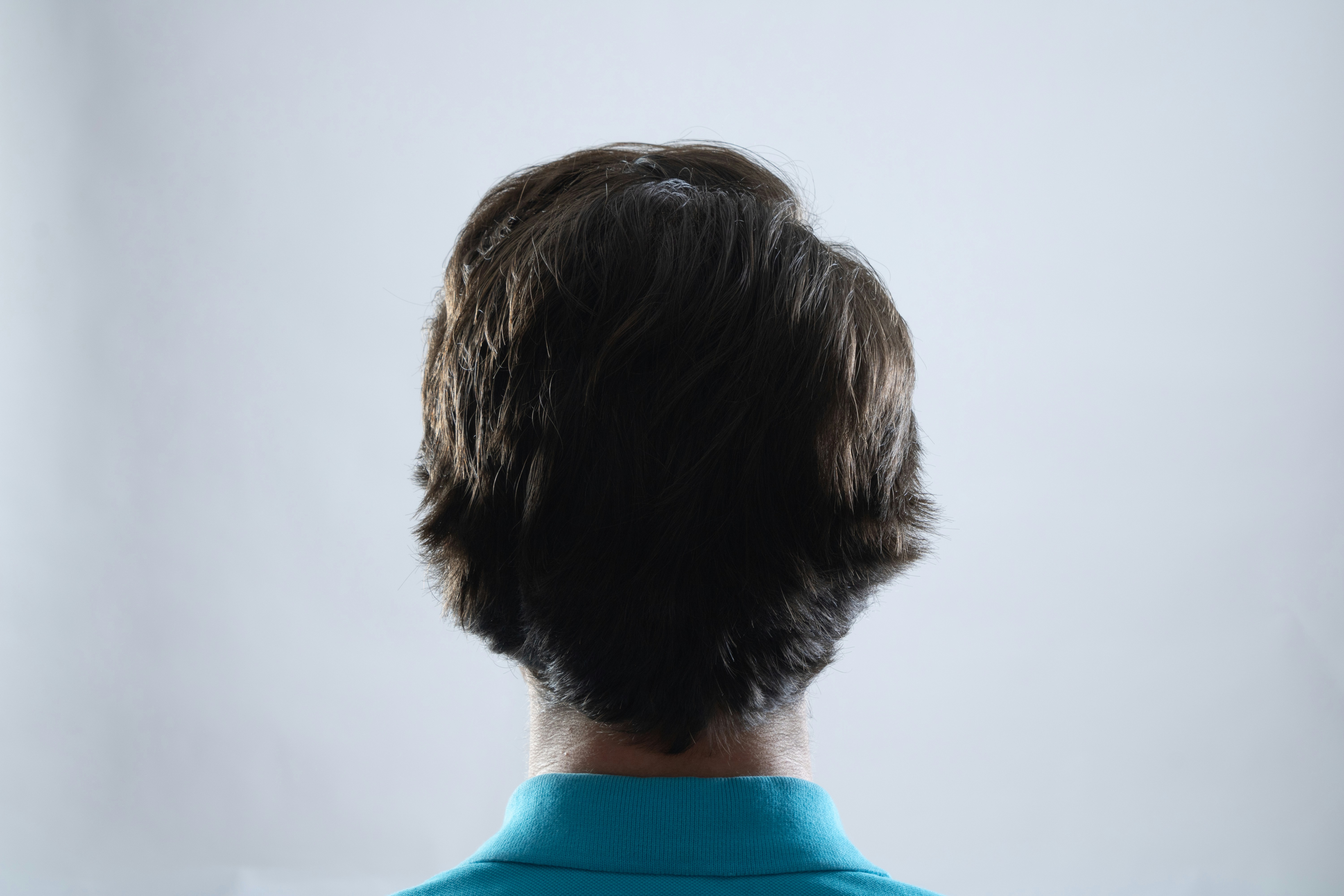 The back of a man's head in a blue shirt