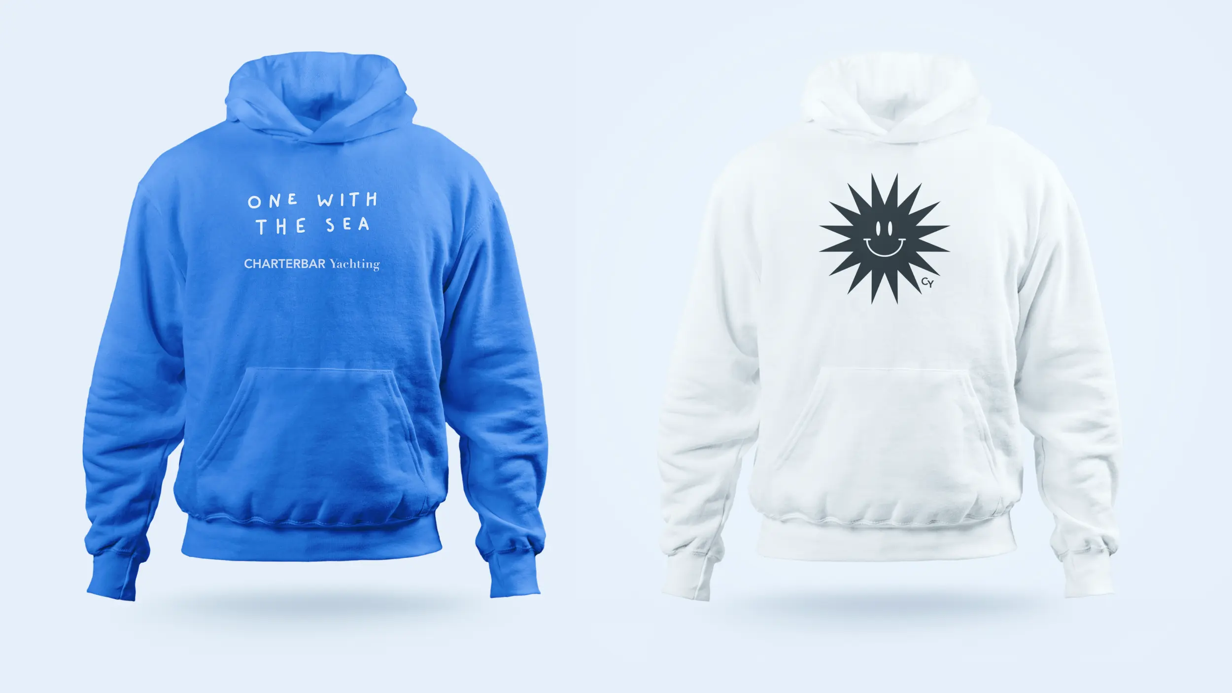 Zwei Hoodies: blaues mit „ONE WITH THE SEA“ und weißes mit Sonnen-Smiley und Initialen CY.