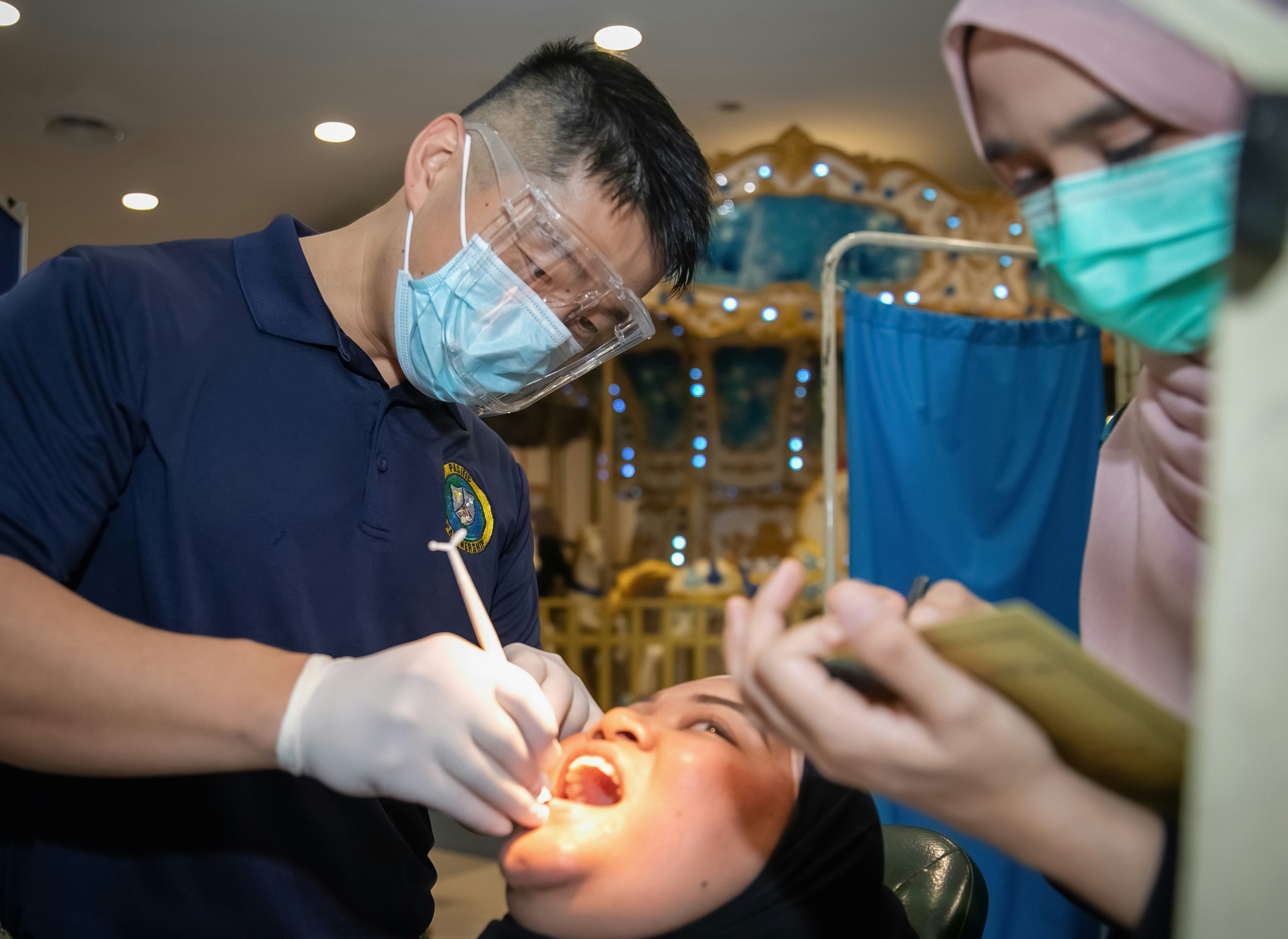 KUANTAN, Malaysia (Sept. 10, 2023) – Lt. Cmdr. Wilson Jing, Pacific Partnership 2023 dental team, conducts a dental exam at a community health fair at Kuantan City Mall during Pacific Partnership 2023, Sept. 10. Now in its 18th year, Pacific Partnership is the largest annual multinational humanitarian assistance and disaster relief preparedness mission conducted in the Indo-Pacific. (U.S. Navy photo by Mass Communication Specialist 1st Class Kegan Kay)