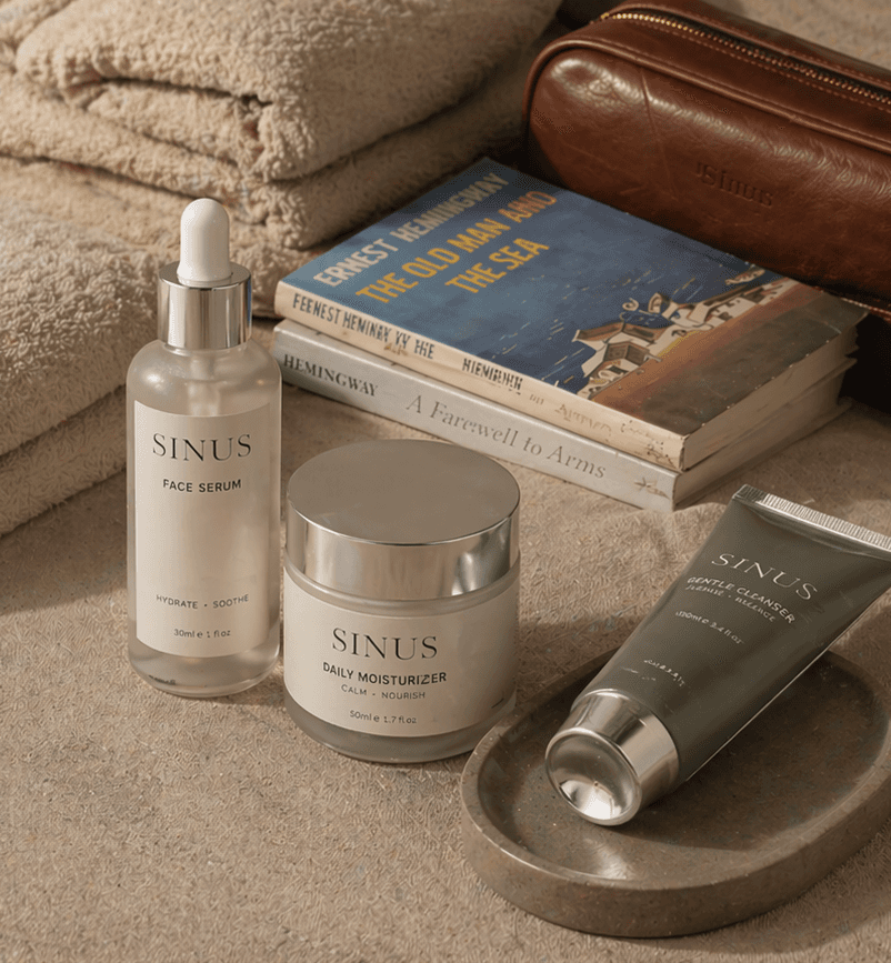 Skincare products including serum, cream, and moisturizer with books on a dark surface.