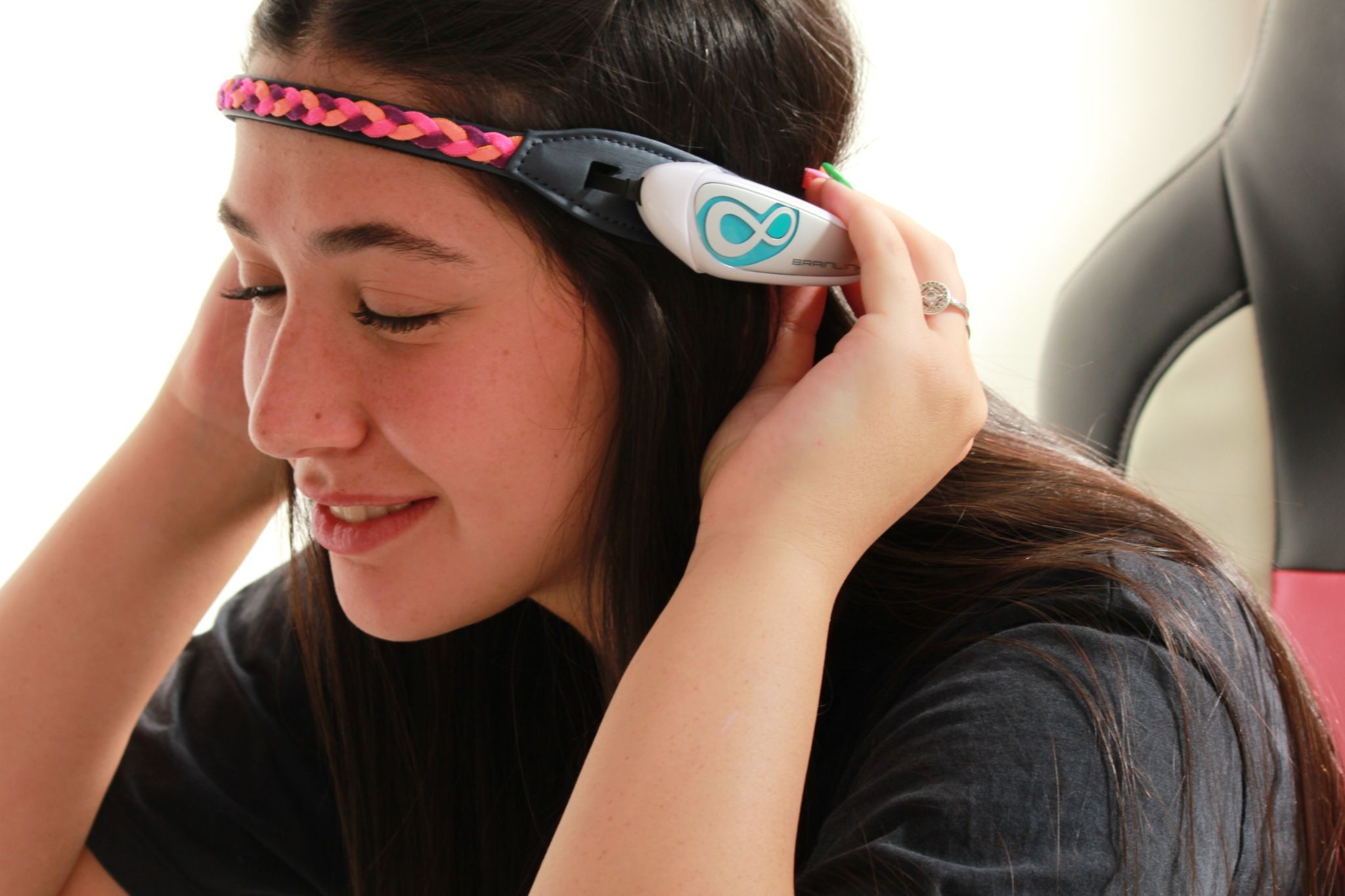 Teen using Excellent Brain neurofeedback headset for structured ADHD training sessions in a clinical care setting.