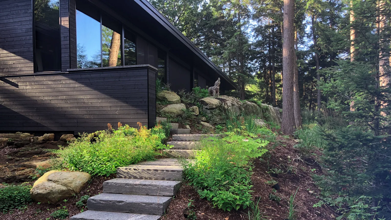 Locally sourced muskoka granite stepping stones around a lush garden.