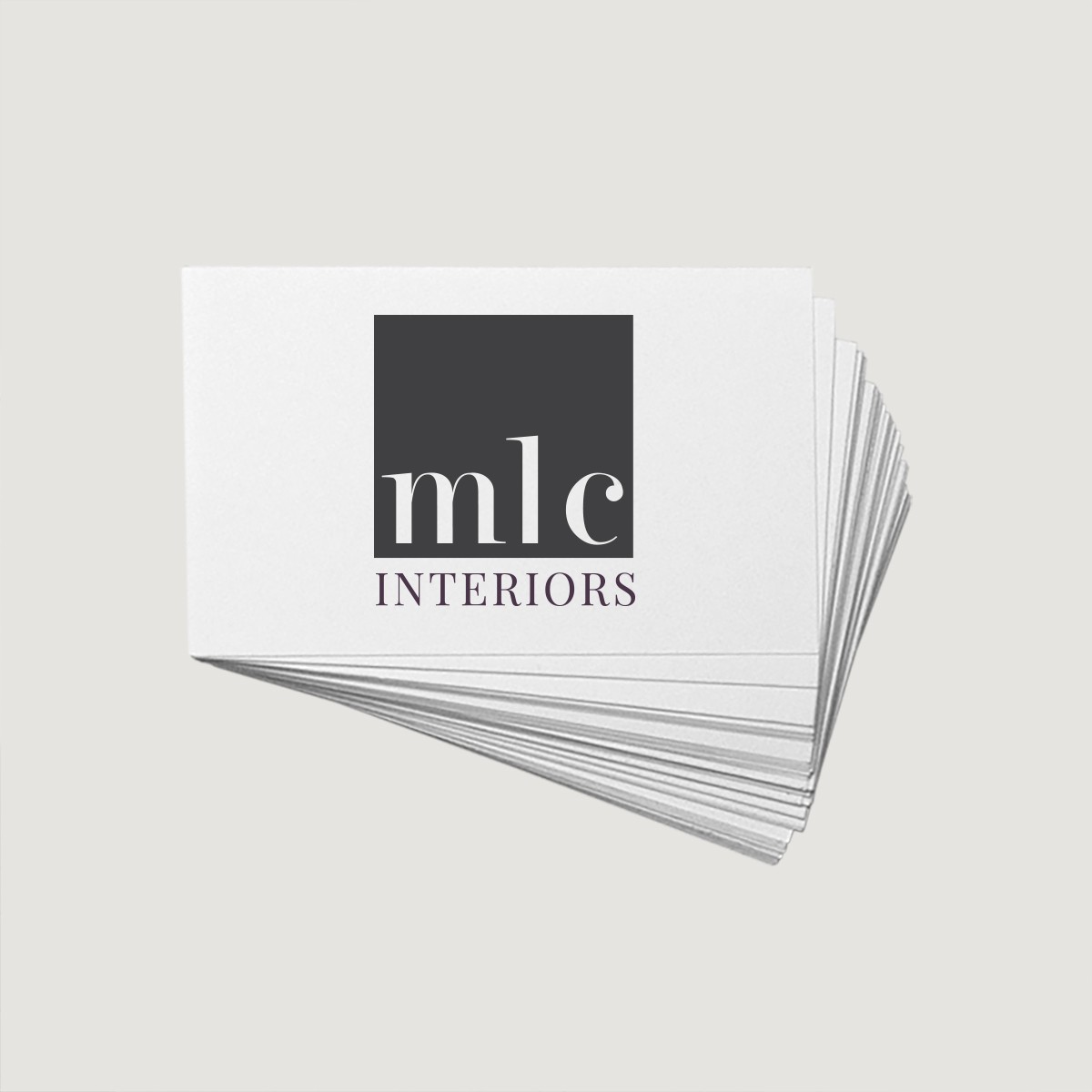 Stack of business cards with MLC Interiors logo in minimalist design.