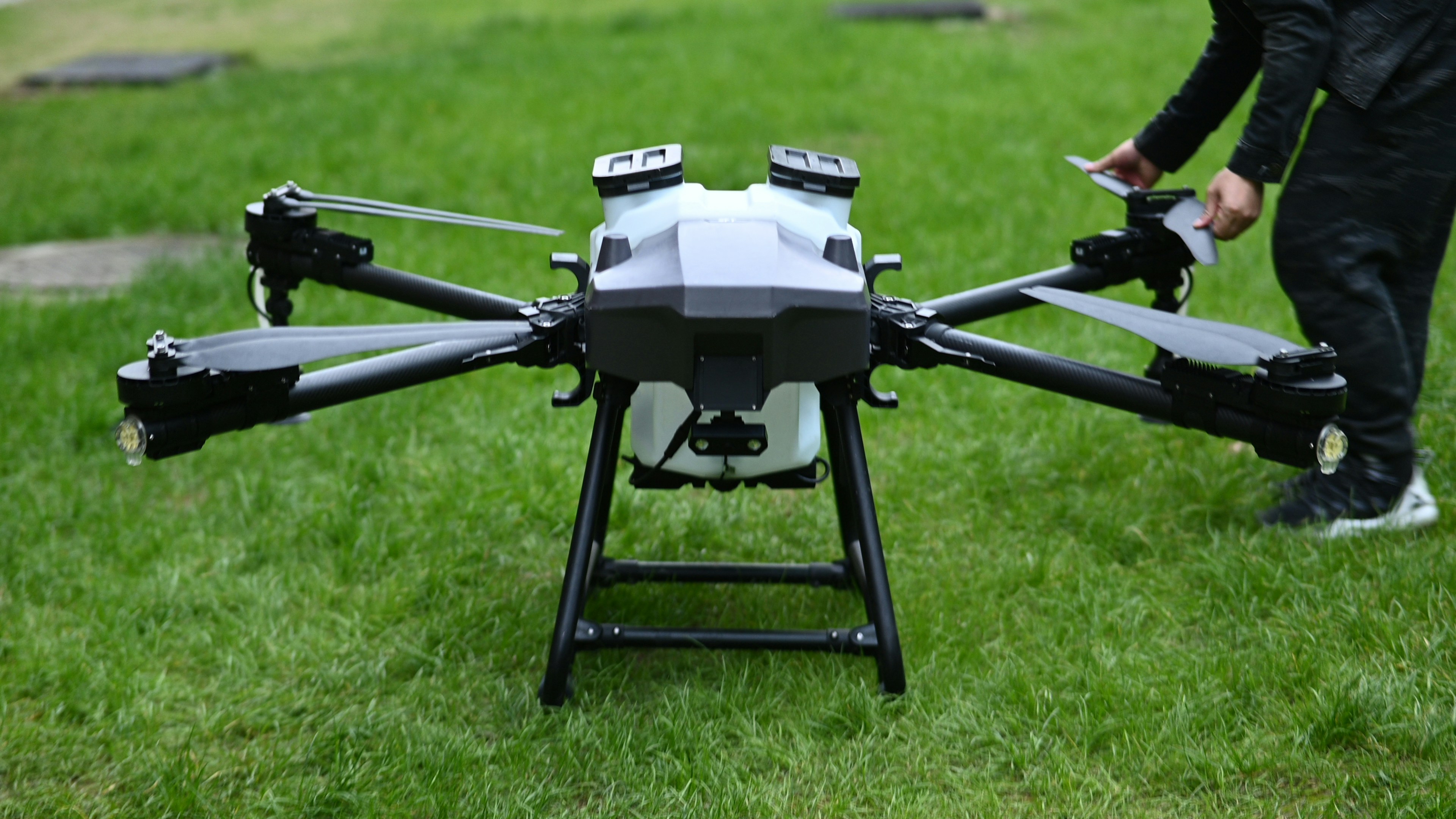 A drone on the ground in a field, ready for agricultural use.