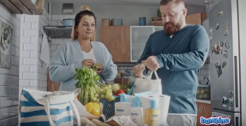 Rodzina rozpakowująca zakupy w kuchni, z produktami marki Bambino