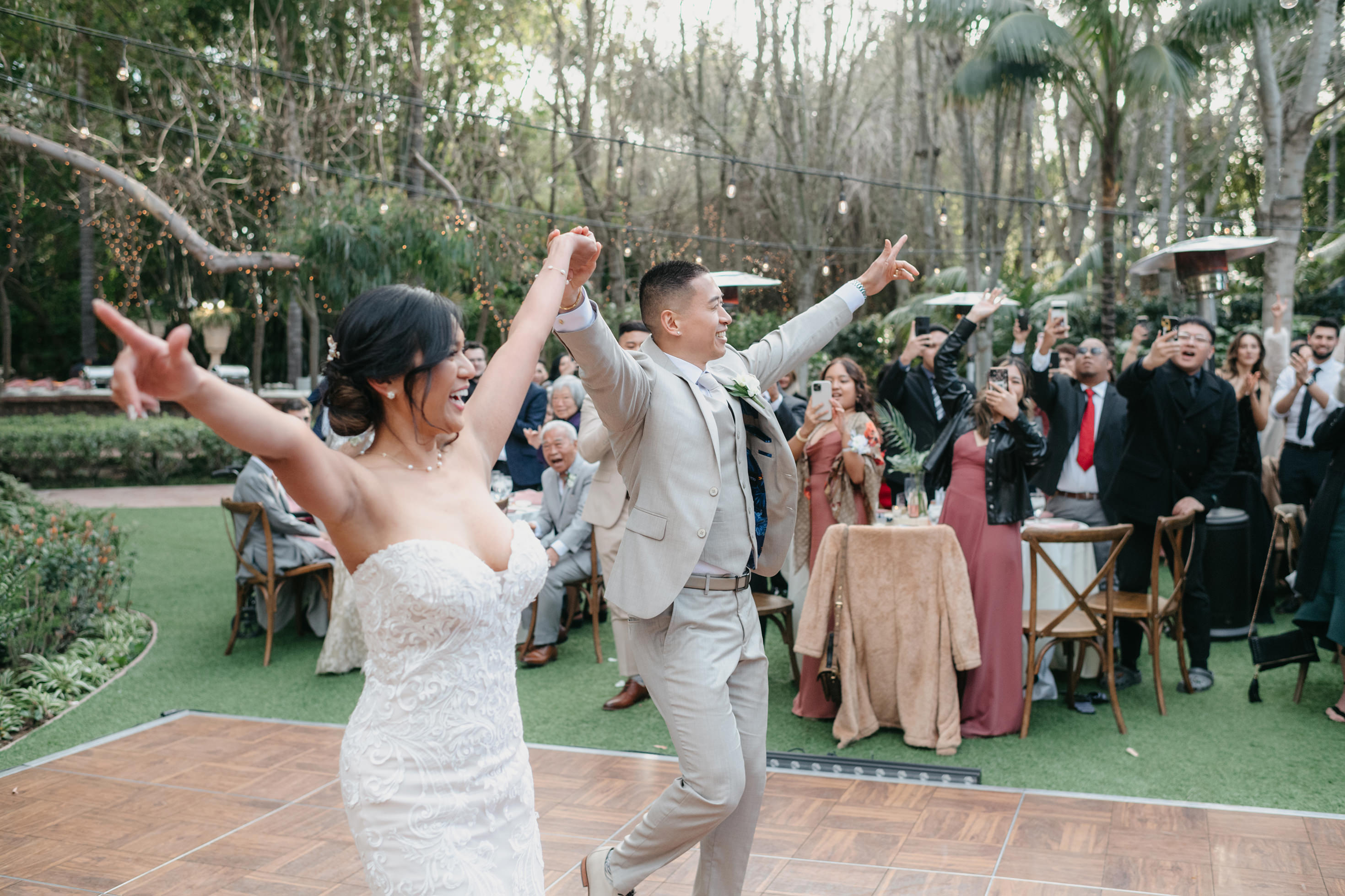 Bride and groom first dance with guests cheering