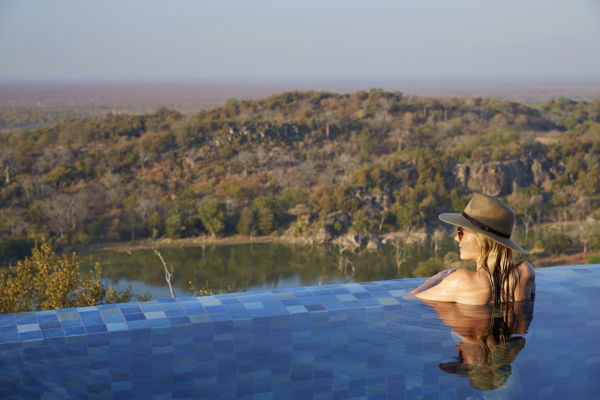 A guest in the rim-flow pool at Singita Malilangwe House, above the Malilangwe Dam