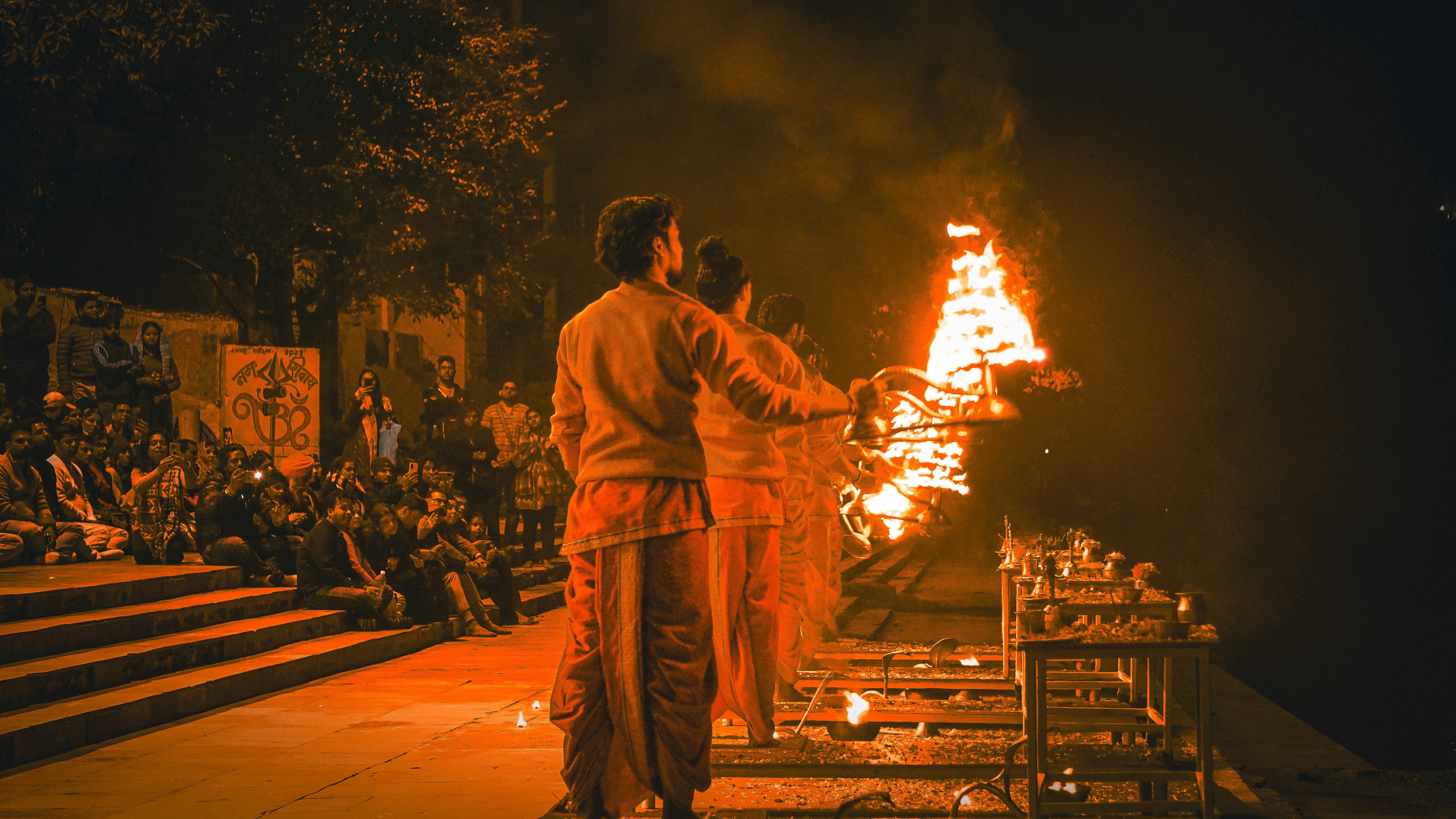 a couple of men standing in front of a fire
